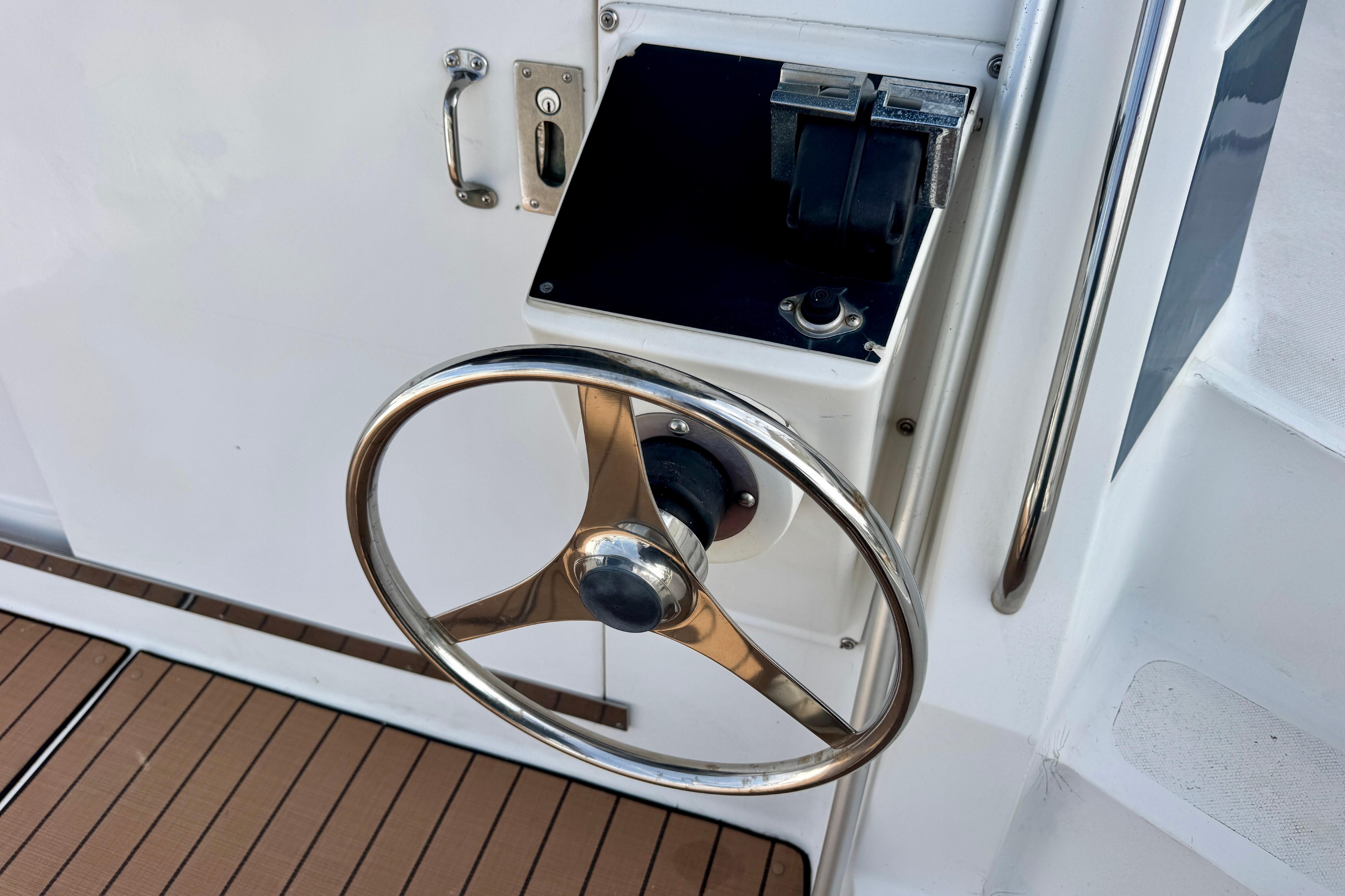 Steering wheel of a 1989 Mediterranean 38 boat, featuring a sleek metal design.