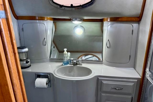 1989 Mediterranean 38 yacht bathroom with sink, mirror, and storage cabinets.