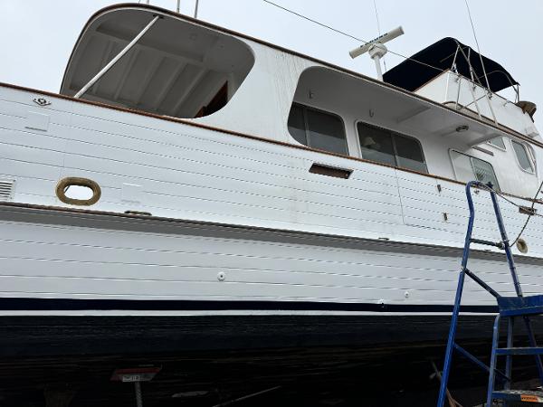 1977 Grand Alaskan Raised Pilothouse yacht on dry dock with blue ladder.