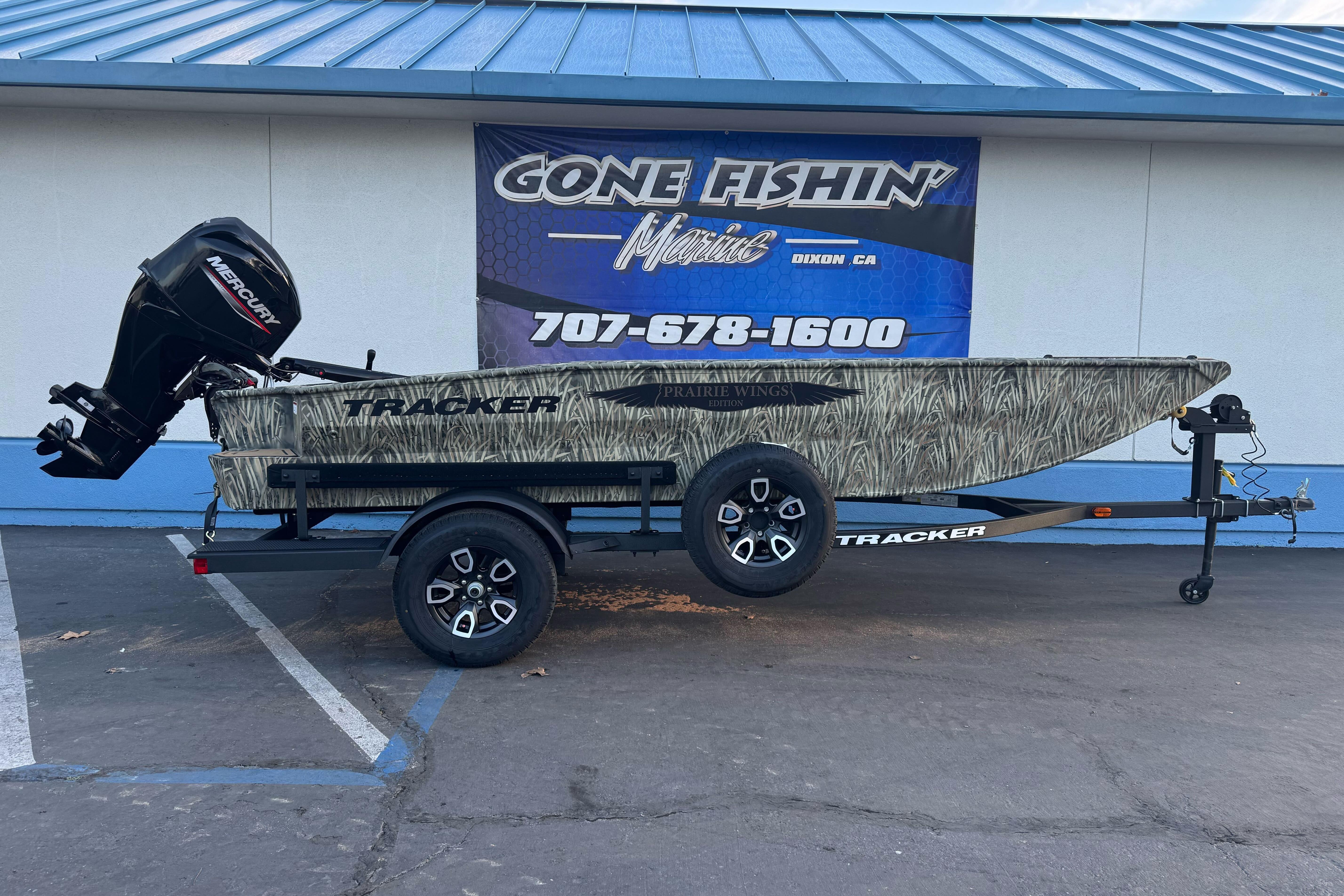 2026 Tracker Grizzly 1650 T Prairie Wings Edition boat on trailer, parked outside dealership.