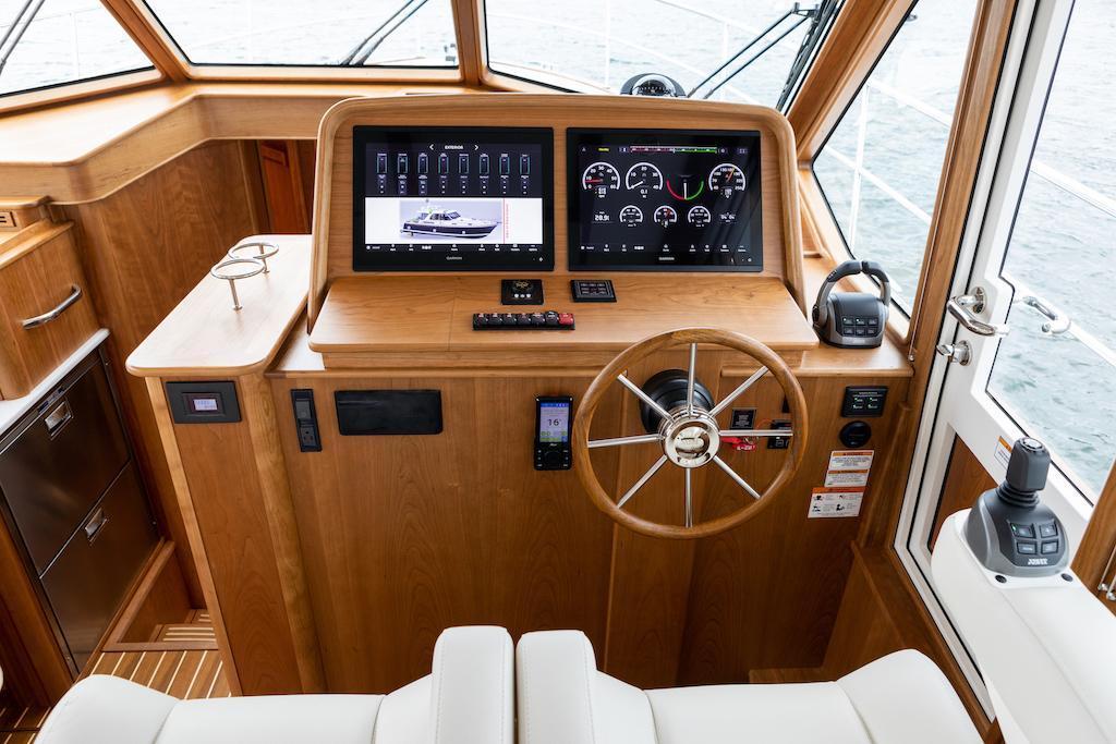 2026 Sabre 43 Salon Express helm with modern navigation displays and wooden finish.