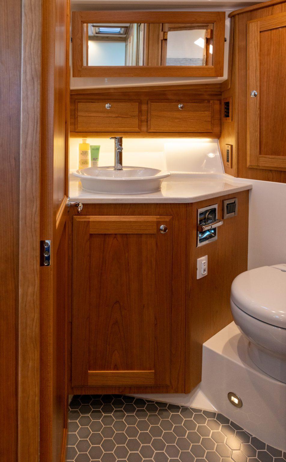 Luxurious bathroom in 2026 Sabre 43 Salon Express yacht with wooden cabinetry and modern fixtures.