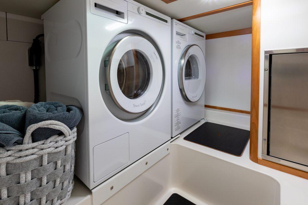 Laundry area in 2026 Sabre 43 Salon Express yacht with washer, dryer, and towels.