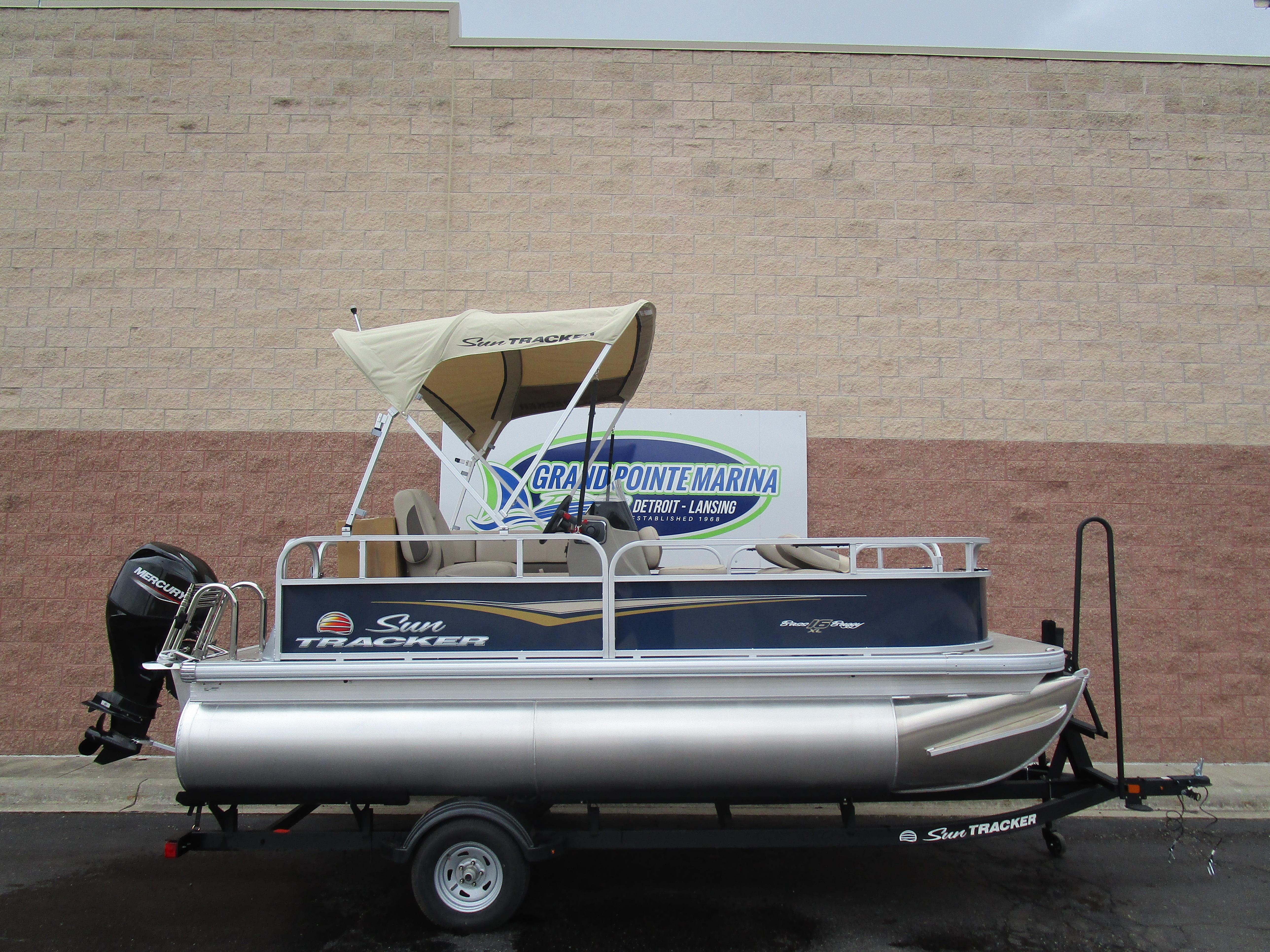 2025 Sun Tracker Bass Buggy 16 pontoon boat on trailer at marina.
