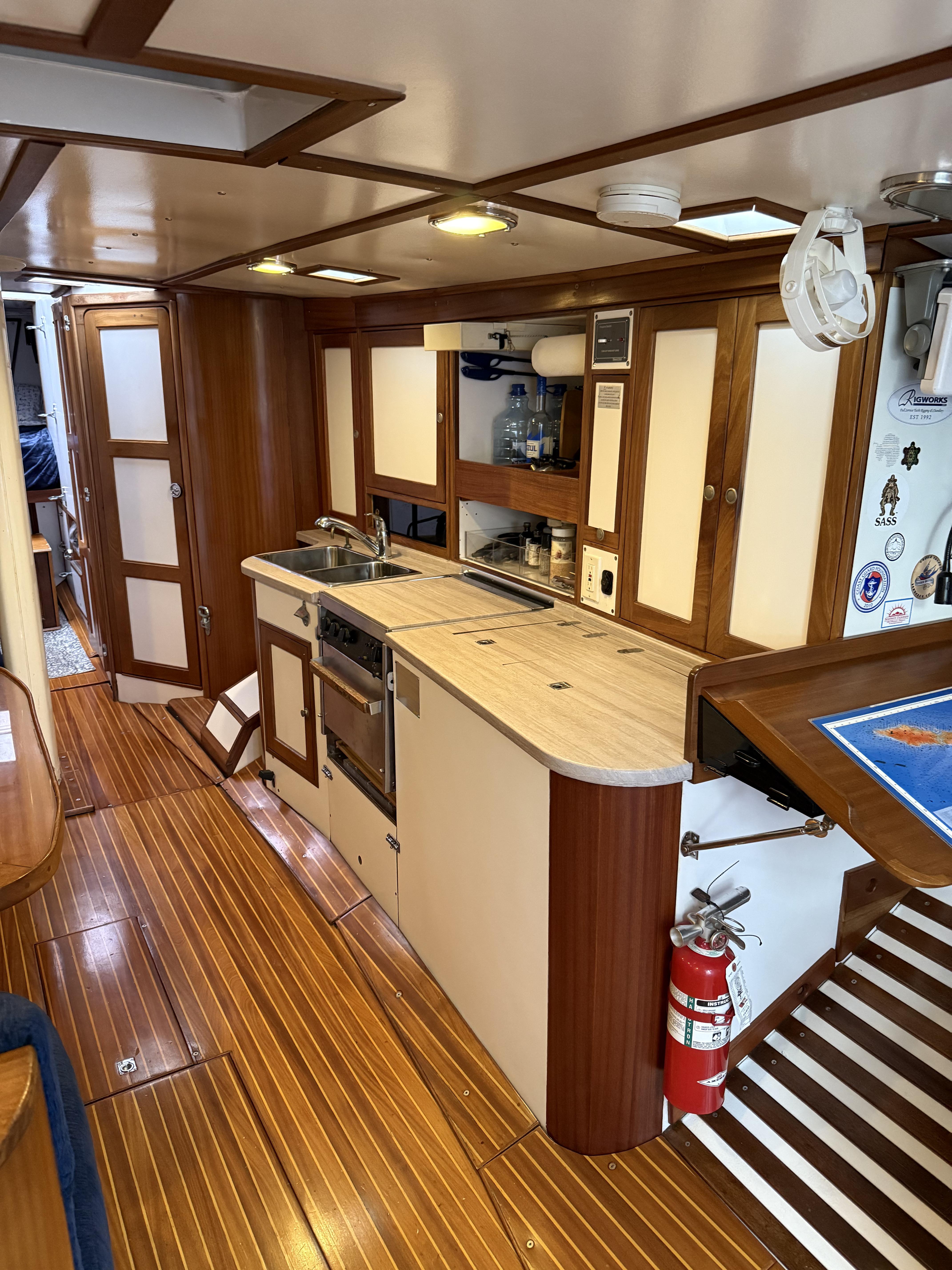 1976 Frers Custom yacht interior with wooden flooring and modern kitchen amenities.