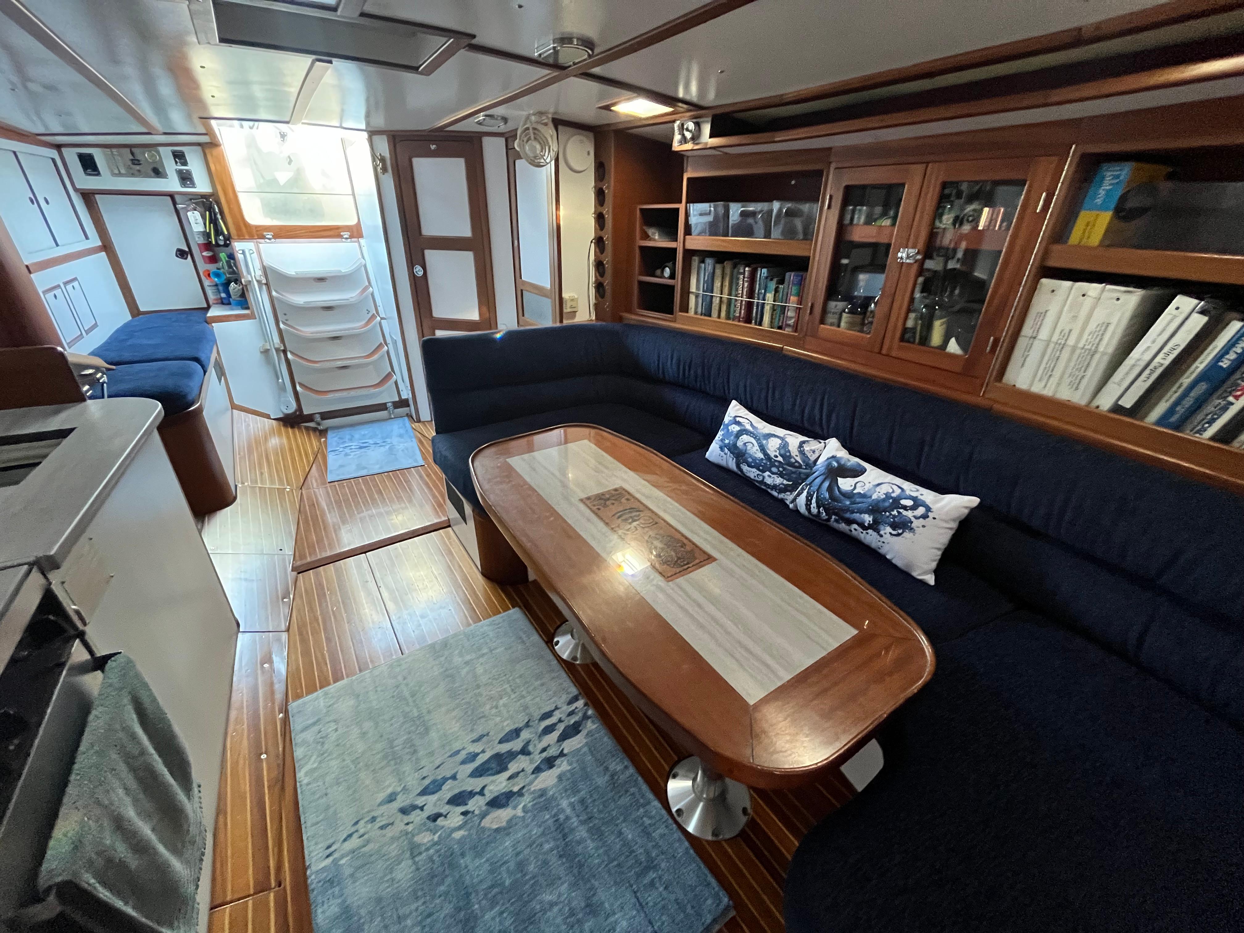 Luxurious 1976 Frers Custom yacht interior with elegant wood finishes and cozy seating area.
