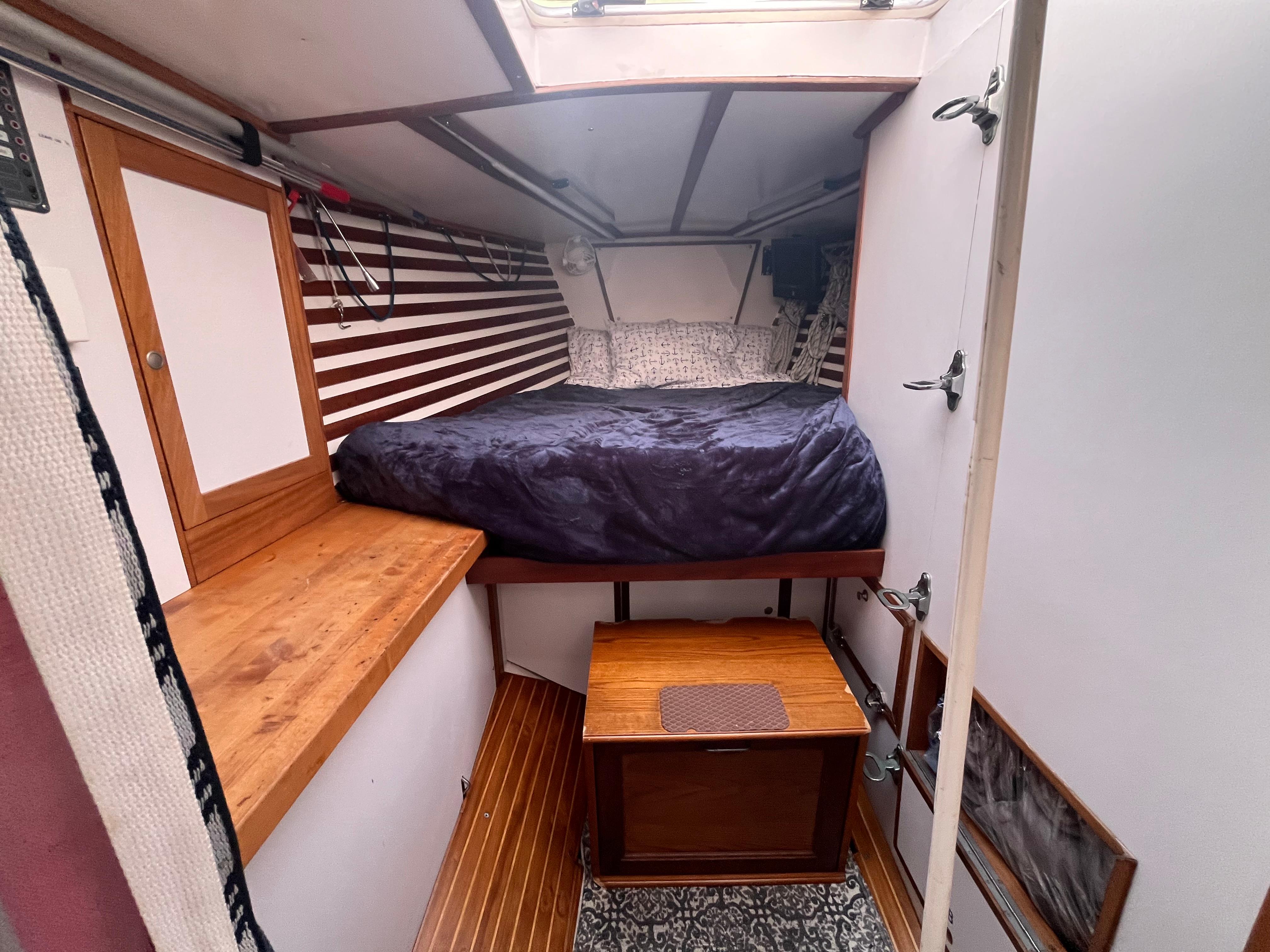 1976 Frers Custom yacht interior with cozy bed, wooden accents, and striped walls.
