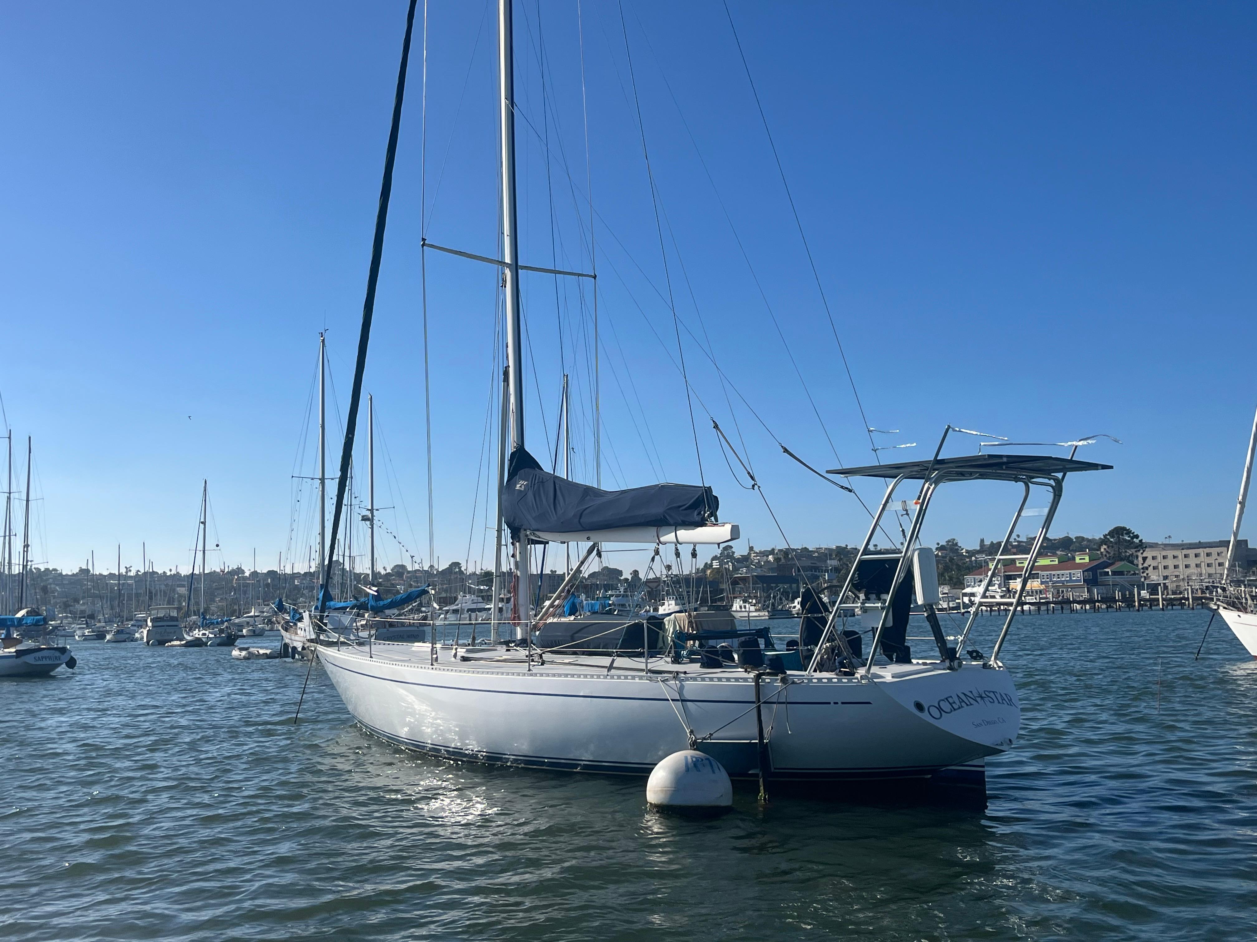 Sailboat in harbor, Frers Custom 1976, sunny day, calm waters, marina background.