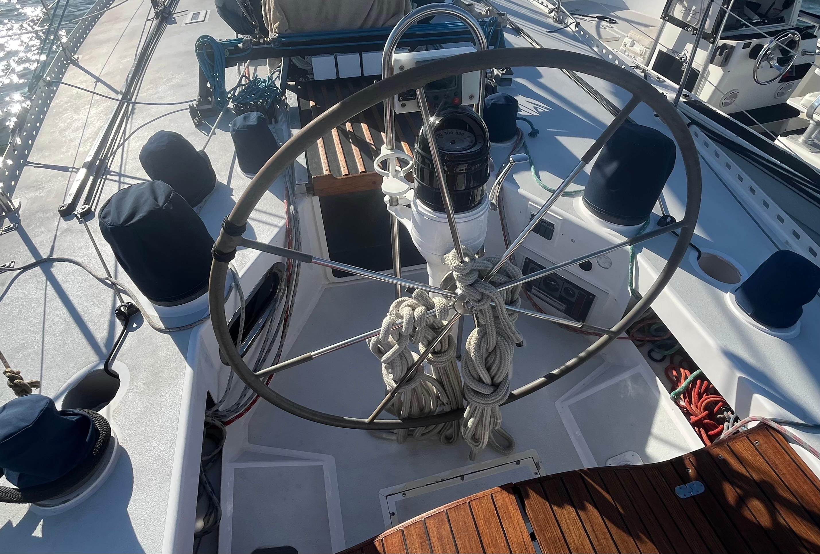 1976 Frers Custom yacht cockpit with large steering wheel and nautical equipment.