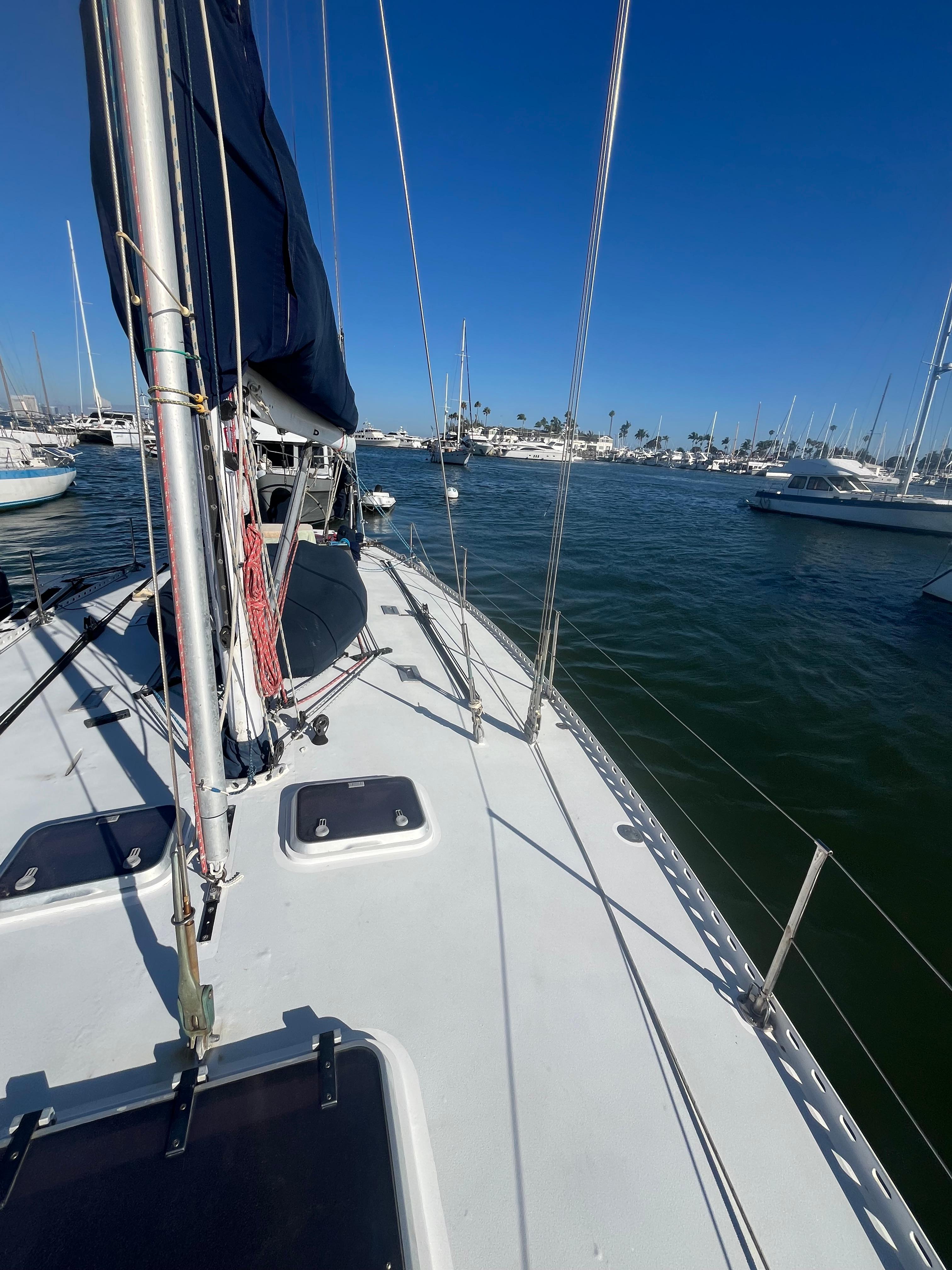 Sailboat deck view, Frers Custom 1976, in a marina under clear blue sky.