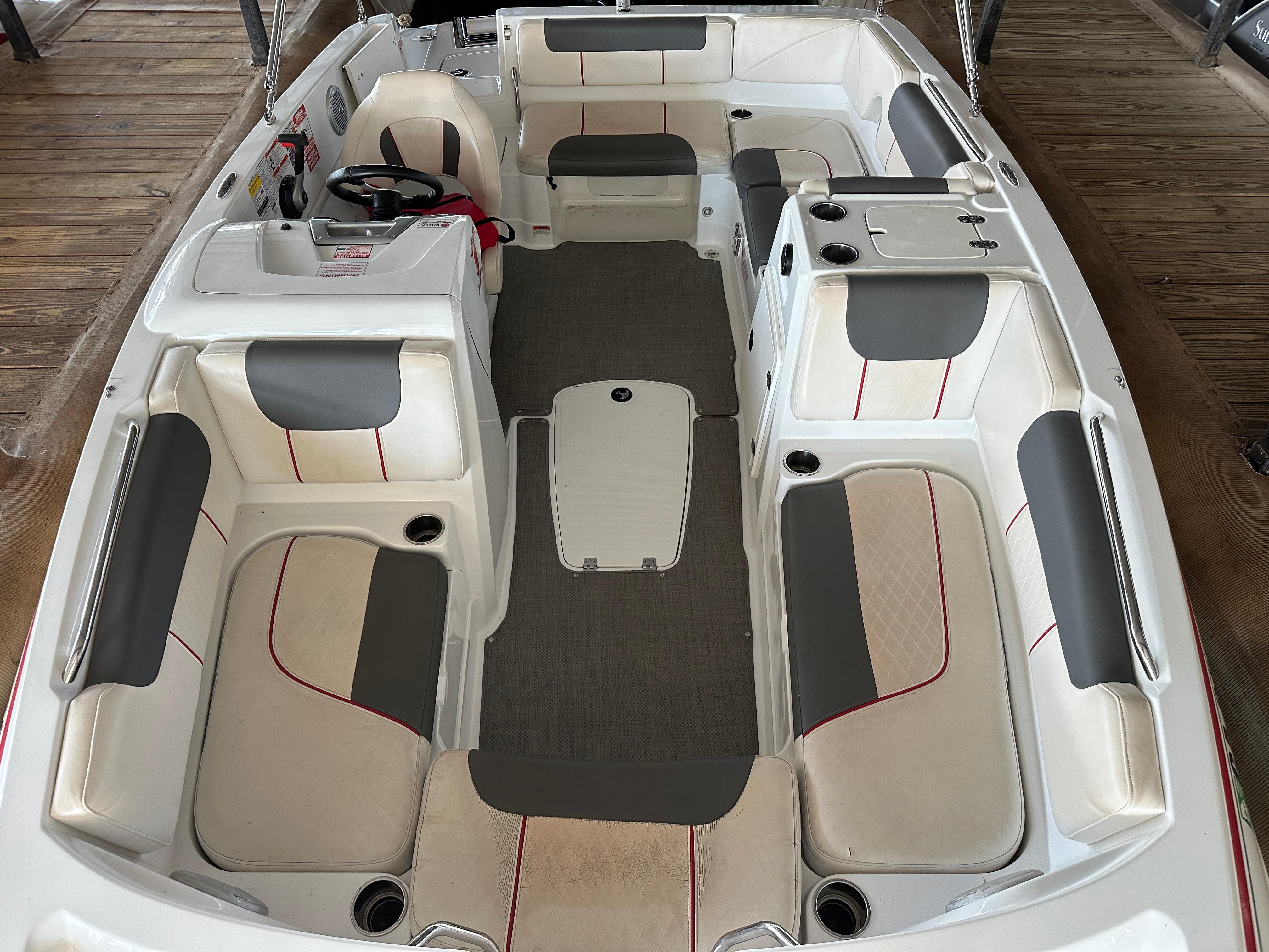 2021 Tahoe 1950 boat interior with gray and white seating, red accents, and steering wheel.