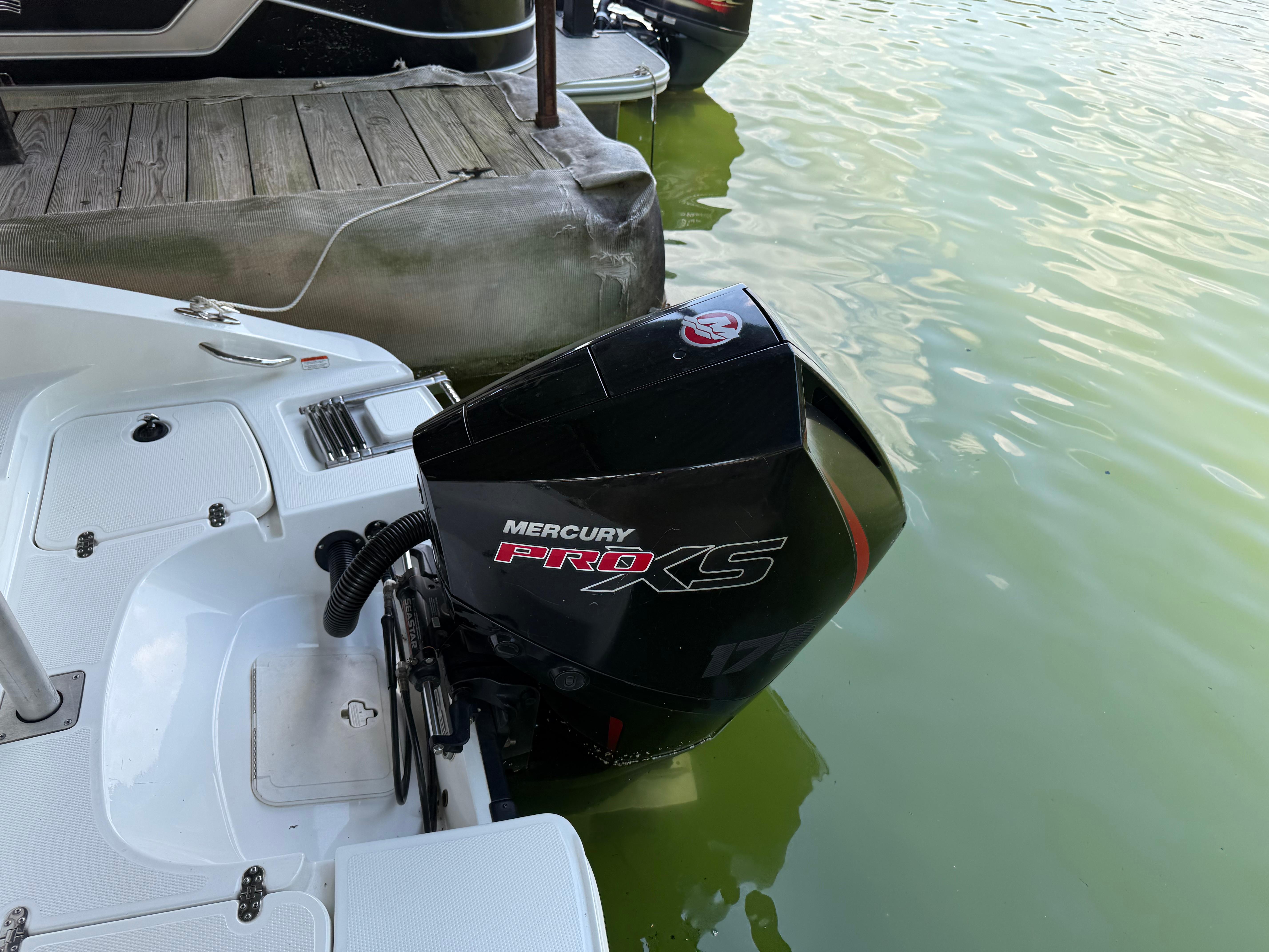 Boat with Mercury Pro XS engine docked on calm water, Tahoe 1950 model, 2021.
