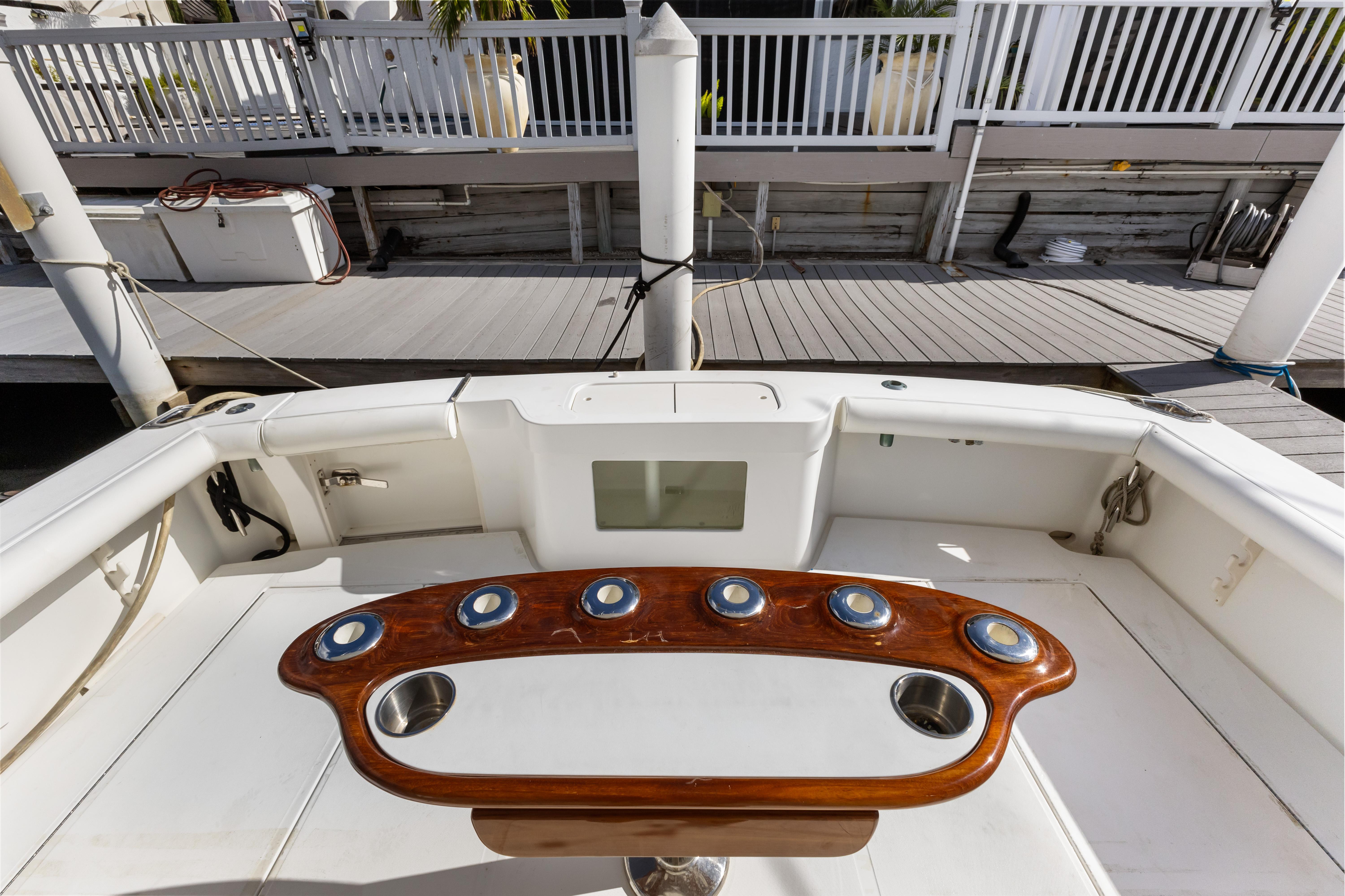Cabo-40 Flybridge 2011-WELL PLAYED FL-US-Cabo 40 Flybridge 2011 boat deck with wooden rod holders and white seating area.-9659613 | Thumbnail