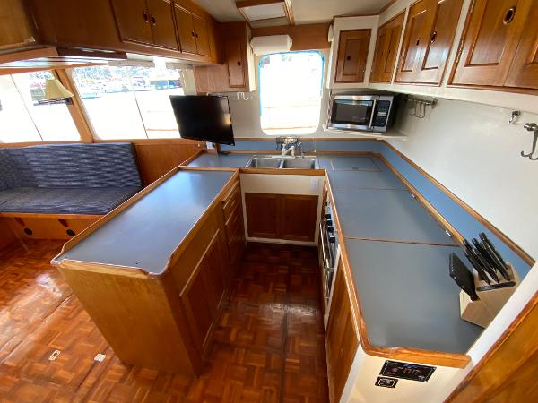 1977 Grand Alaskan Raised Pilothouse kitchen with wood cabinetry and modern appliances.