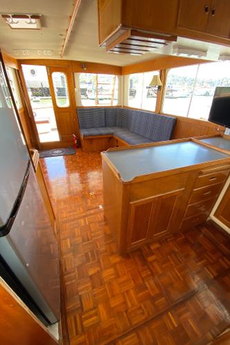 Interior of 1977 Grand Alaskan Raised Pilothouse with wood flooring and seating area.