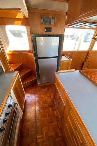 1977 Grand Alaskan Raised Pilothouse kitchen with wood cabinetry and modern appliances.