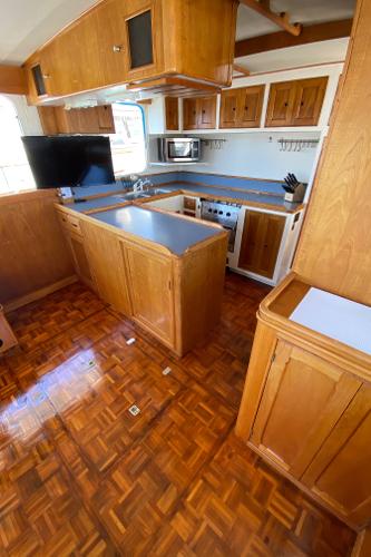 1977 Grand Alaskan Raised Pilothouse kitchen with wood cabinetry and parquet flooring.