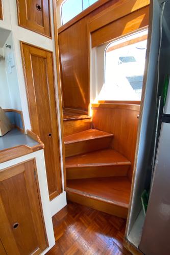 Wooden staircase in 1977 Grand Alaskan Raised Pilothouse yacht interior.