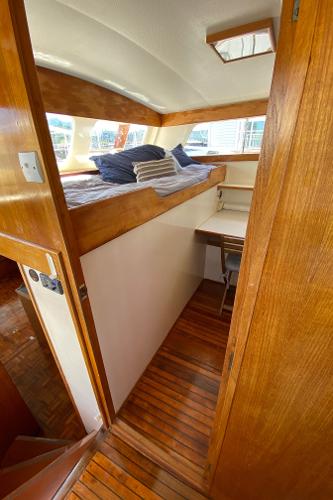 1977 Grand Alaskan Raised Pilothouse interior with wooden finishes and cozy sleeping area.