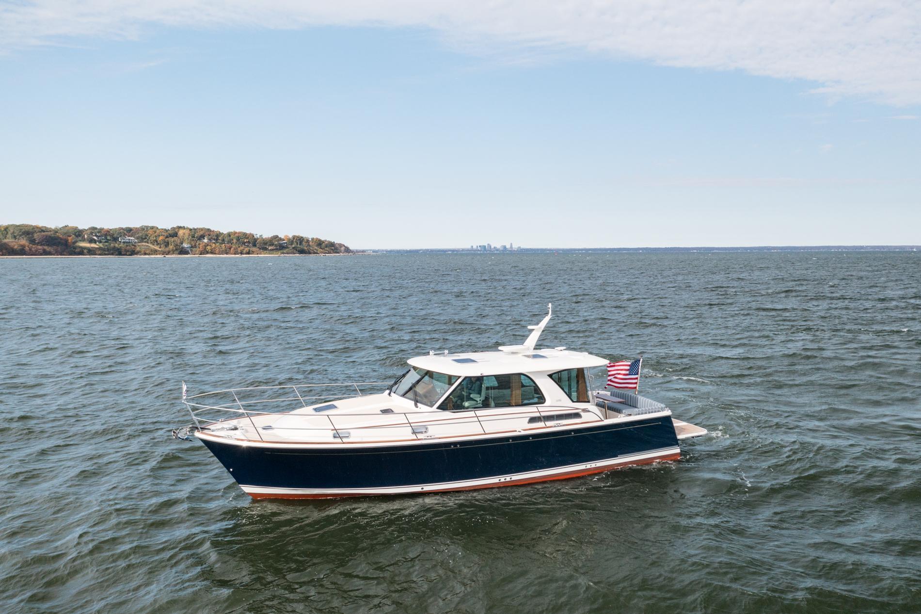 2025 Sabre 43 Salon Express yacht cruising on open water with distant shoreline.