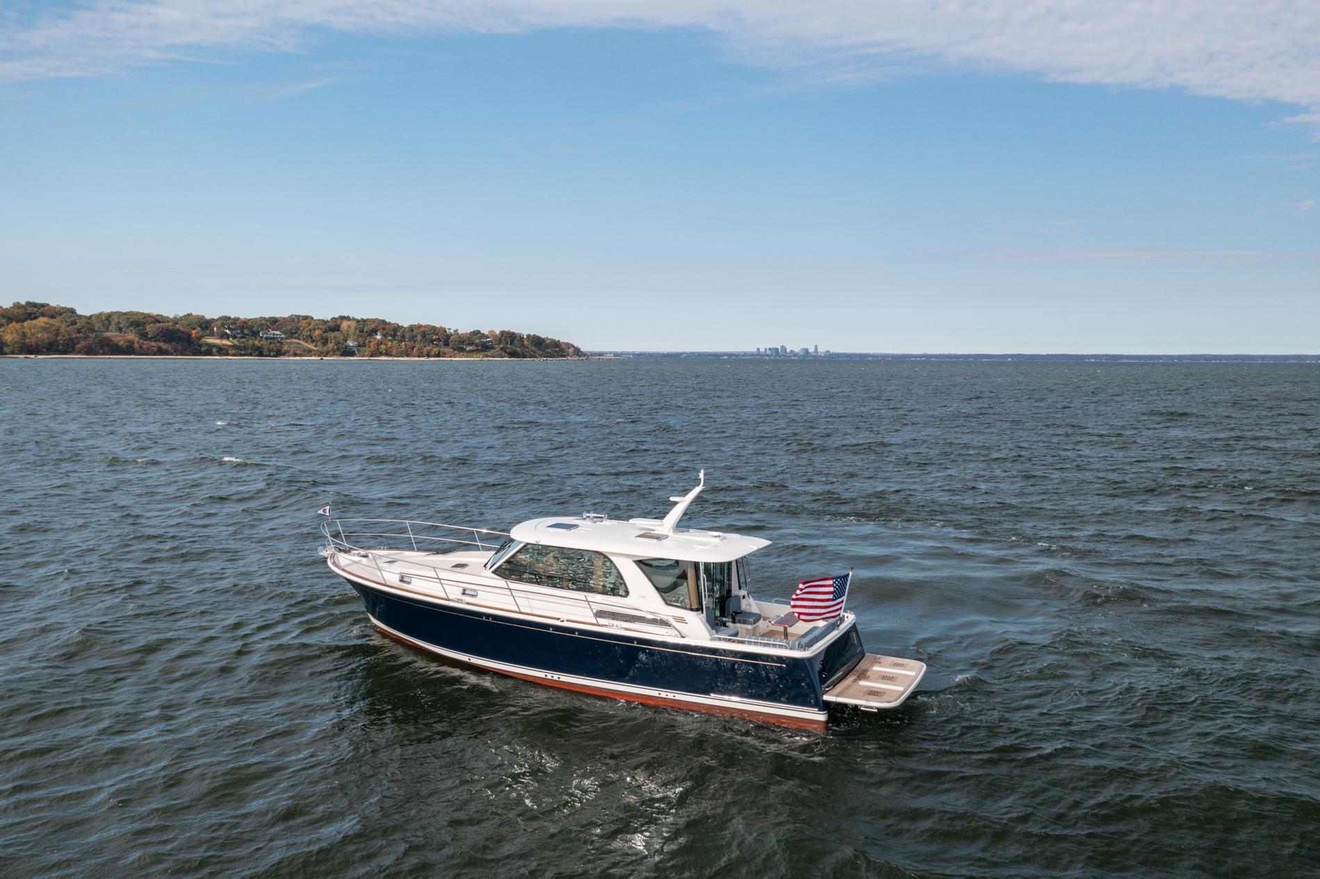 2025 Sabre 43 Salon Express yacht cruising on open water with distant shoreline.