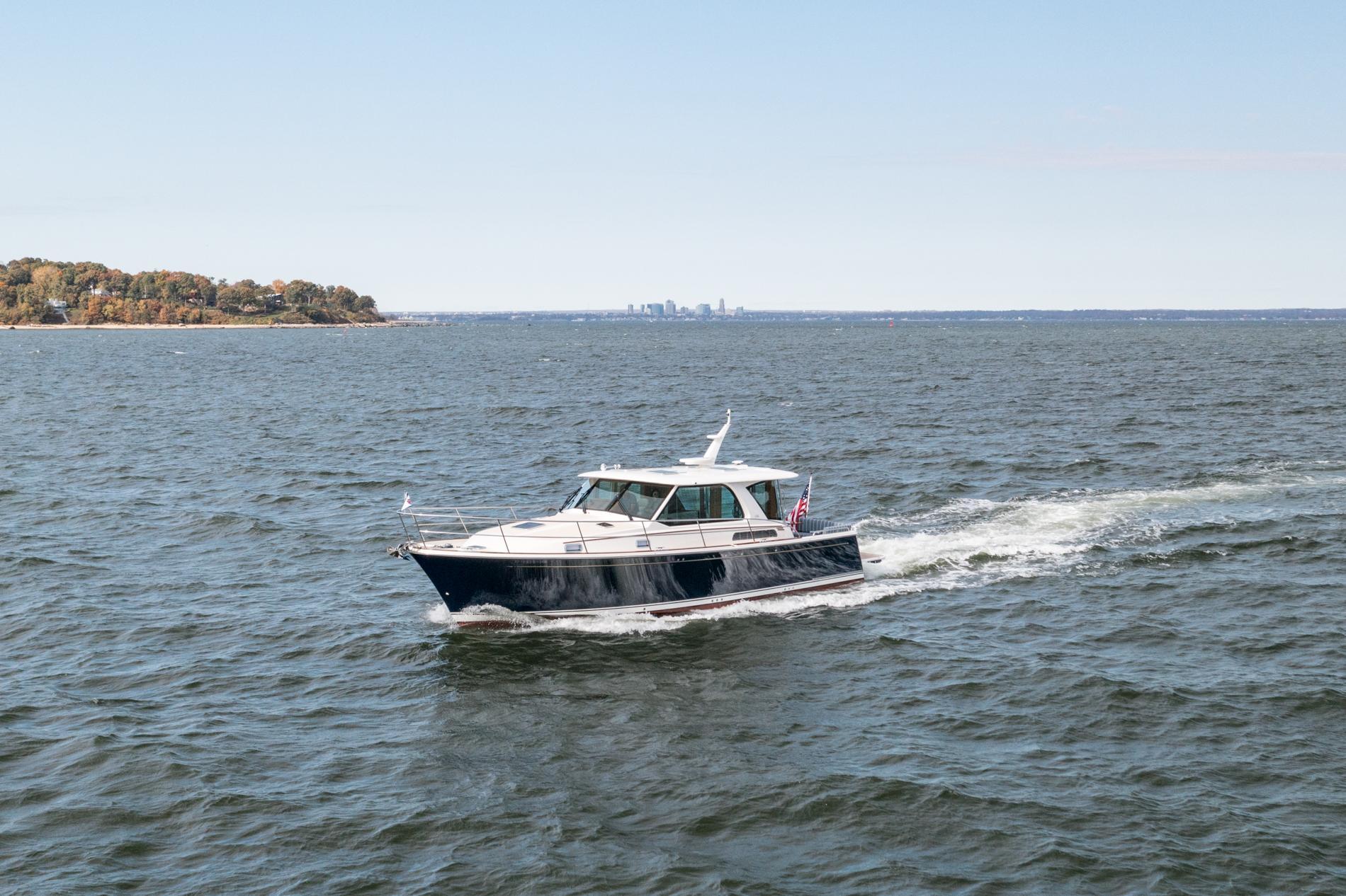 2025 Sabre 43 Salon Express cruising on open water with distant shoreline.