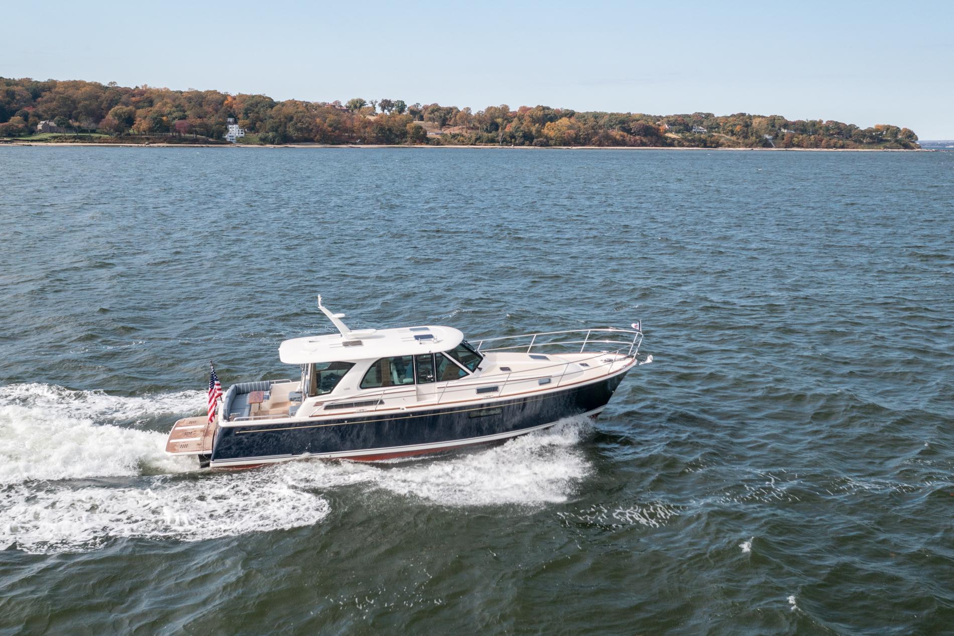 2025 Sabre 43 Salon Express cruising on open water, scenic coastline in background.