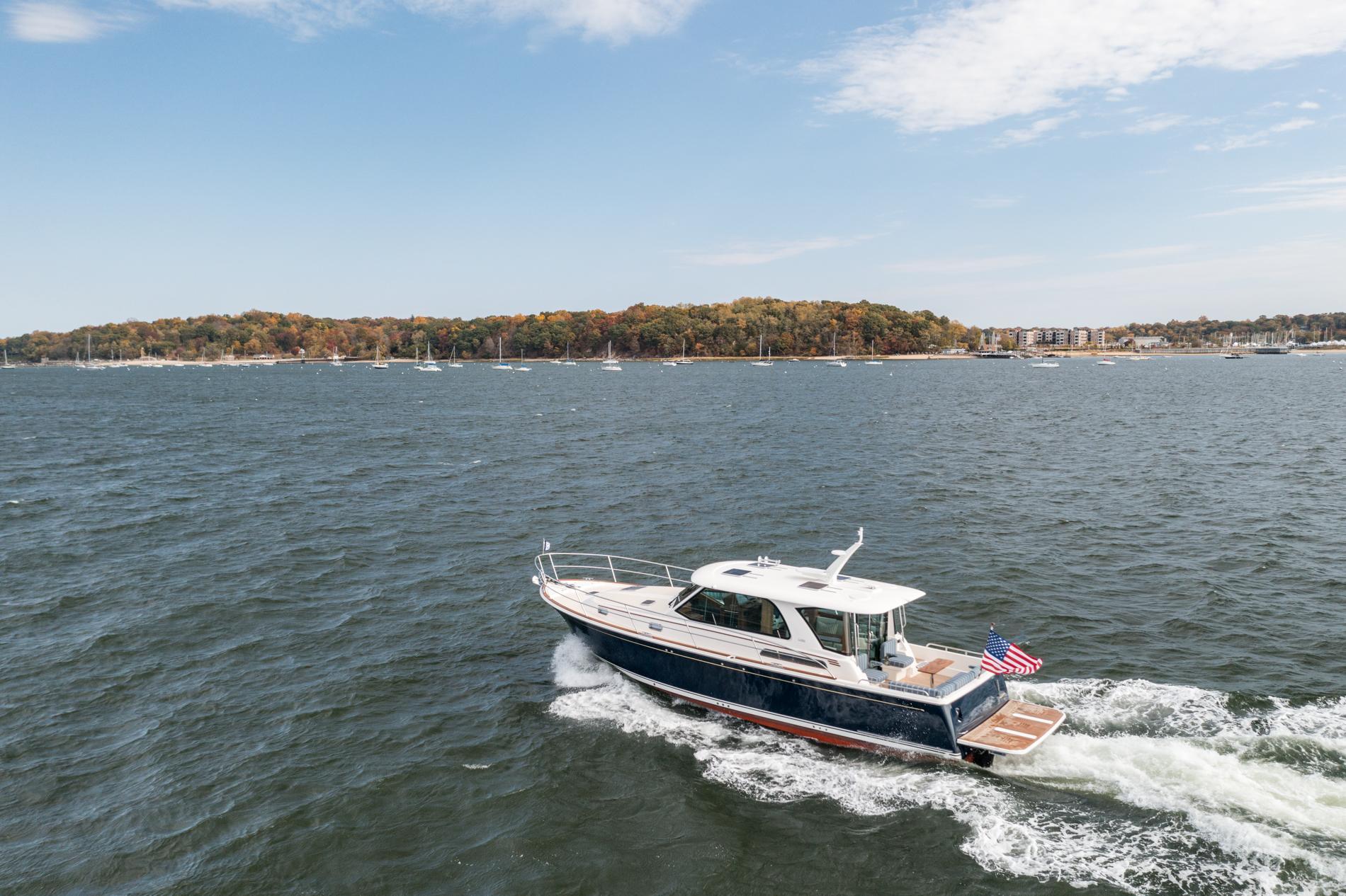 2025 Sabre 43 Salon Express cruising on a scenic lake with autumn foliage.