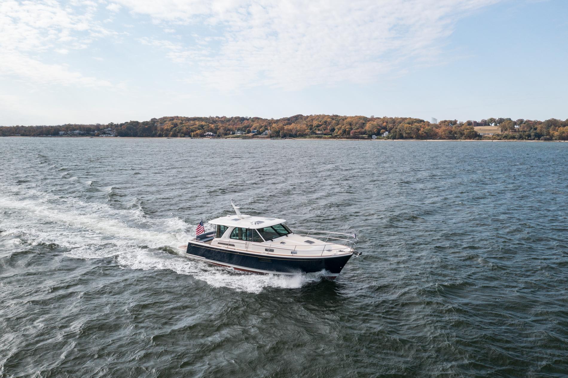 2025 Sabre 43 Salon Express cruising on a scenic lake with autumn foliage.