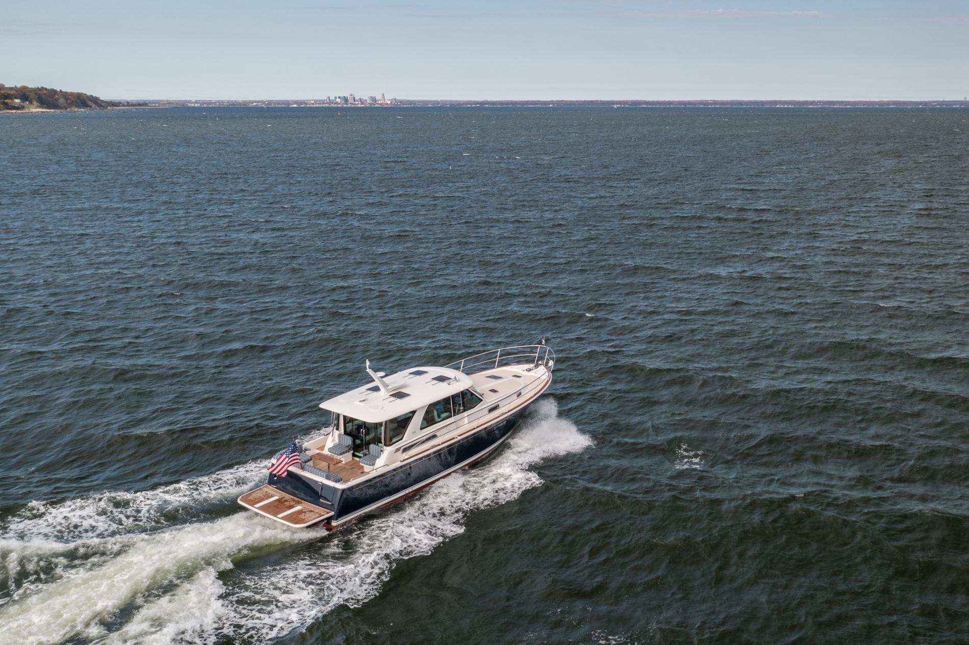 2025 Sabre 43 Salon Express cruising on open water, displaying sleek design and American flag.