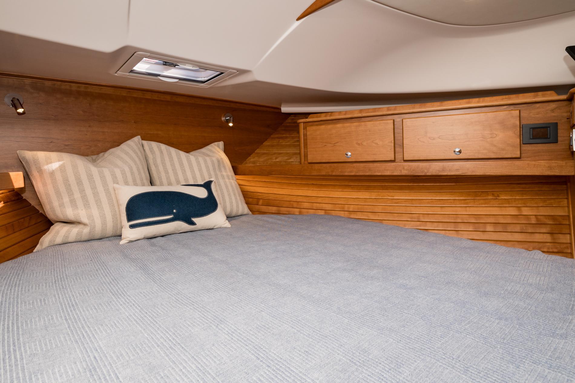 Cozy cabin interior of 2025 Sabre 43 Salon Express with wooden accents and decorative pillows.