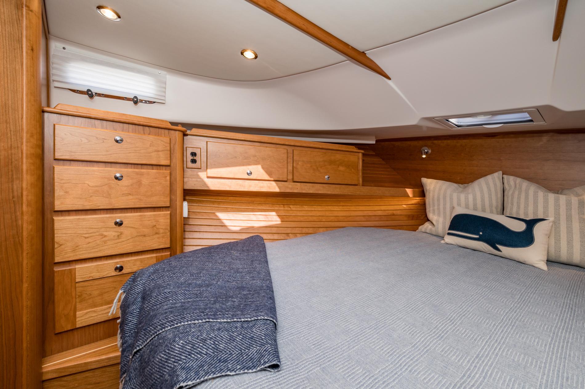 Luxurious 2025 Sabre 43 Salon Express cabin with wooden cabinetry and cozy bedding.