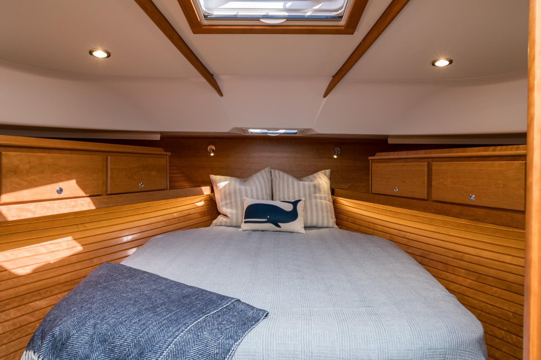 Luxurious cabin interior of 2025 Sabre 43 Salon Express with cozy bedding and wooden finish.