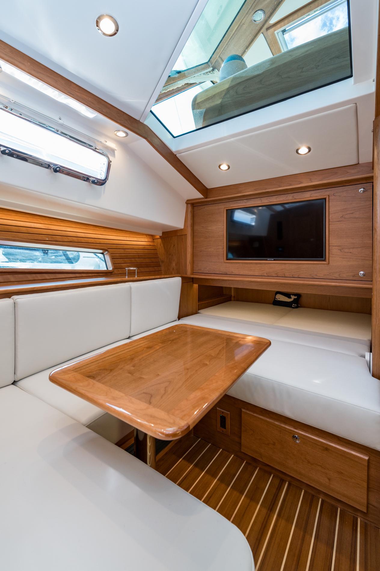 2025 Sabre 43 Salon Express interior with wood finish, skylight, and seating area.