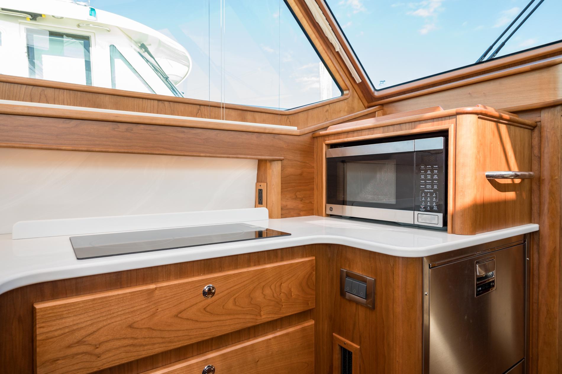 Modern kitchen interior of 2025 Sabre 43 Salon Express yacht with microwave and sleek design.