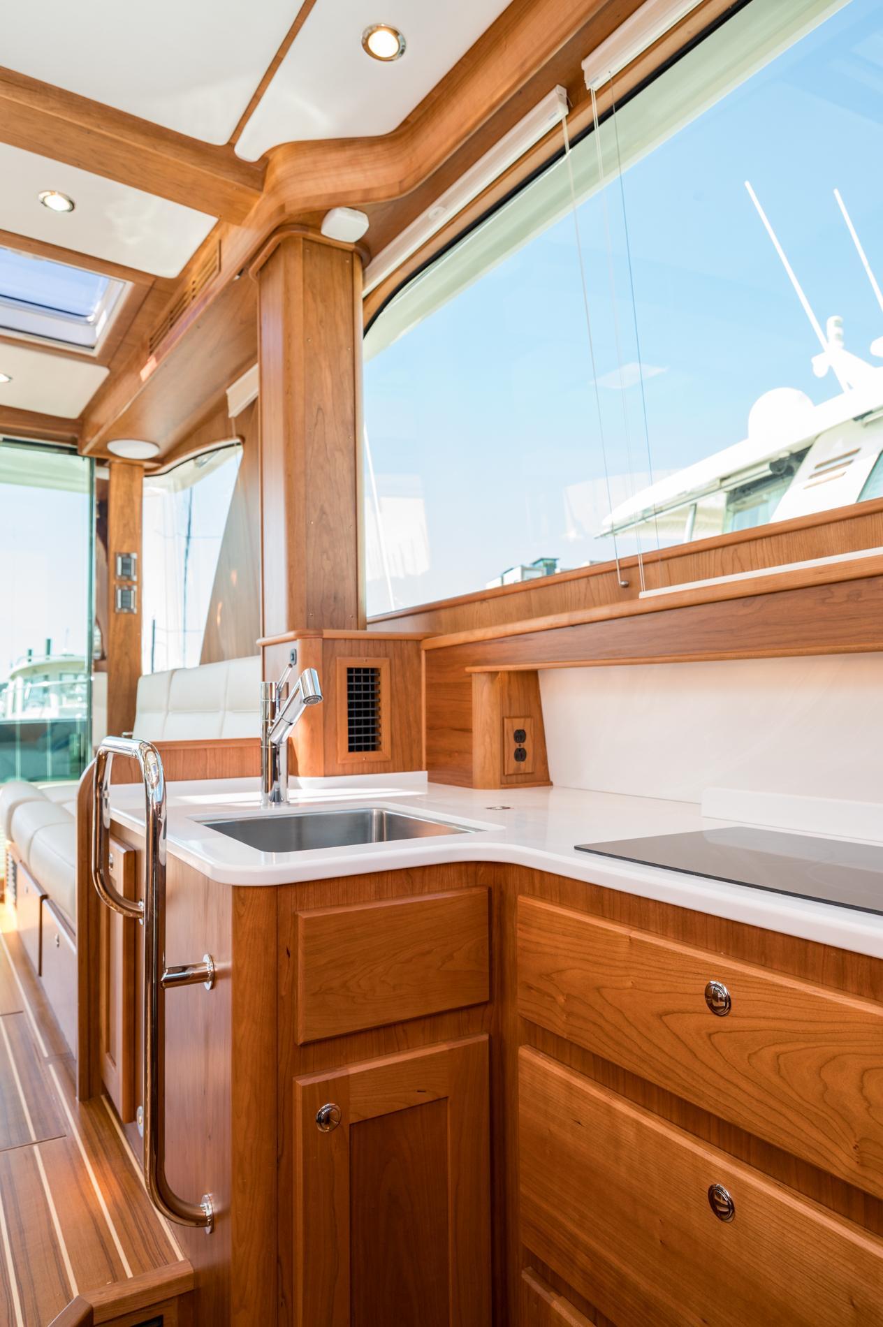 Luxurious interior of 2025 Sabre 43 Salon Express yacht with wooden cabinetry and modern amenities.