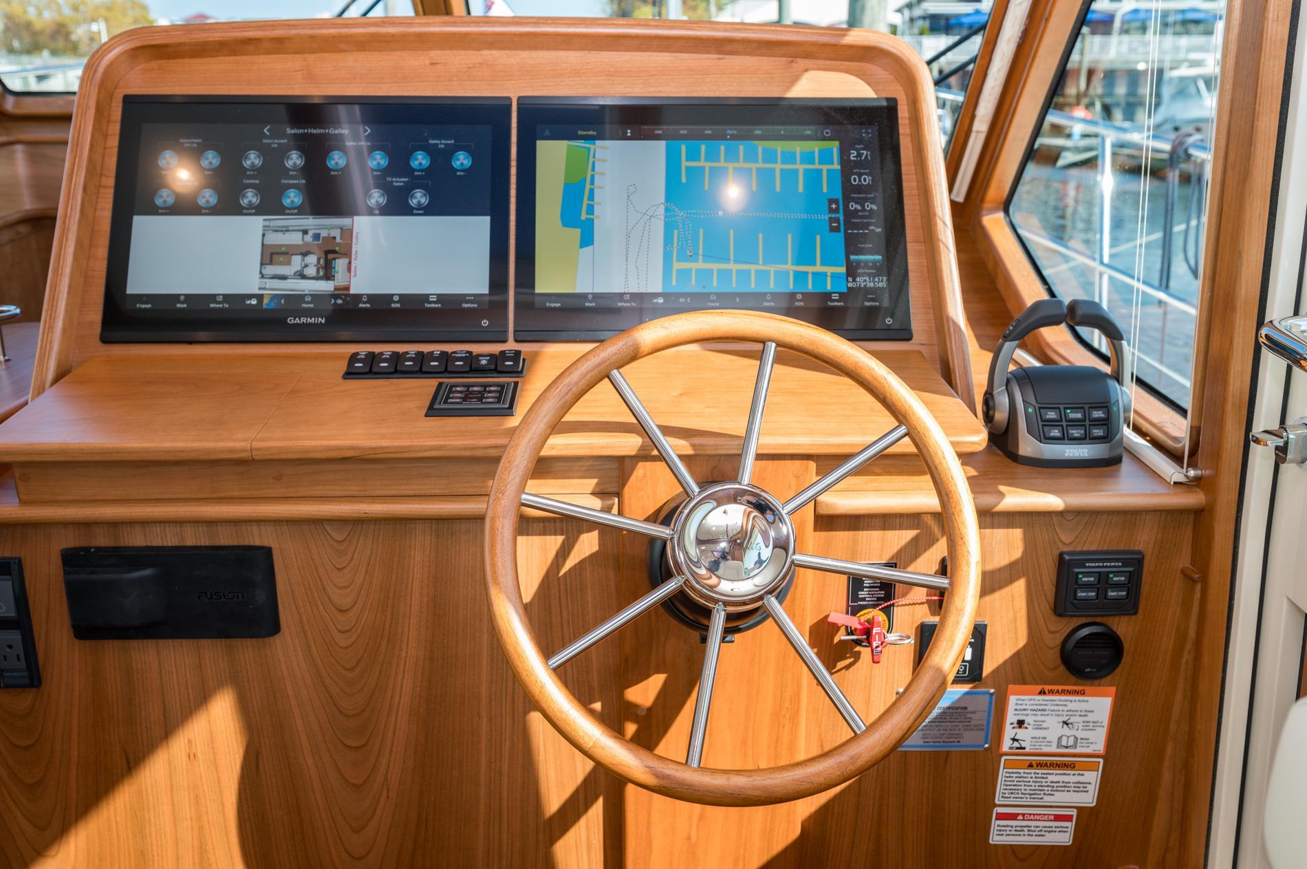2025 Sabre 43 Salon Express helm with dual screens and wooden steering wheel.