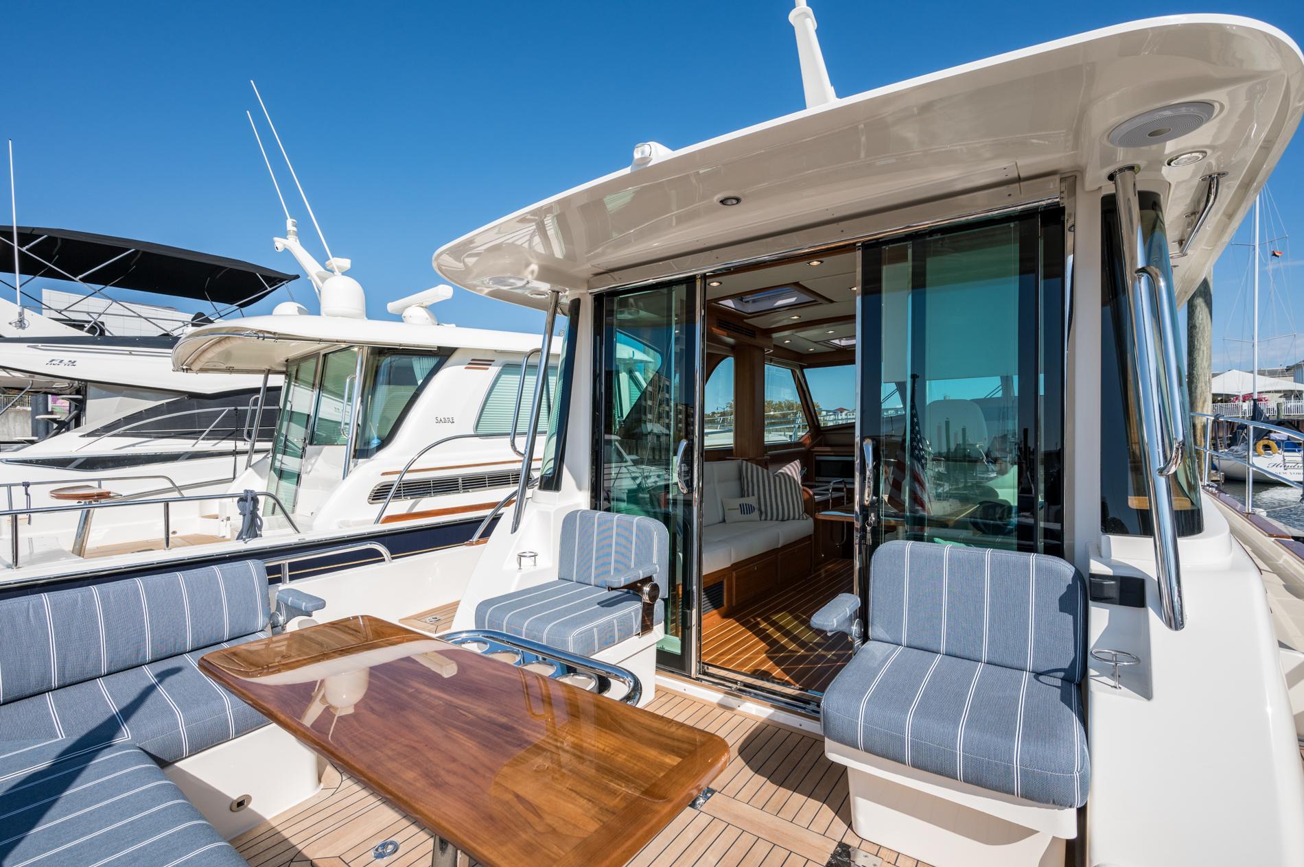 2025 Sabre 43 Salon Express yacht with elegant seating and wooden table on deck.