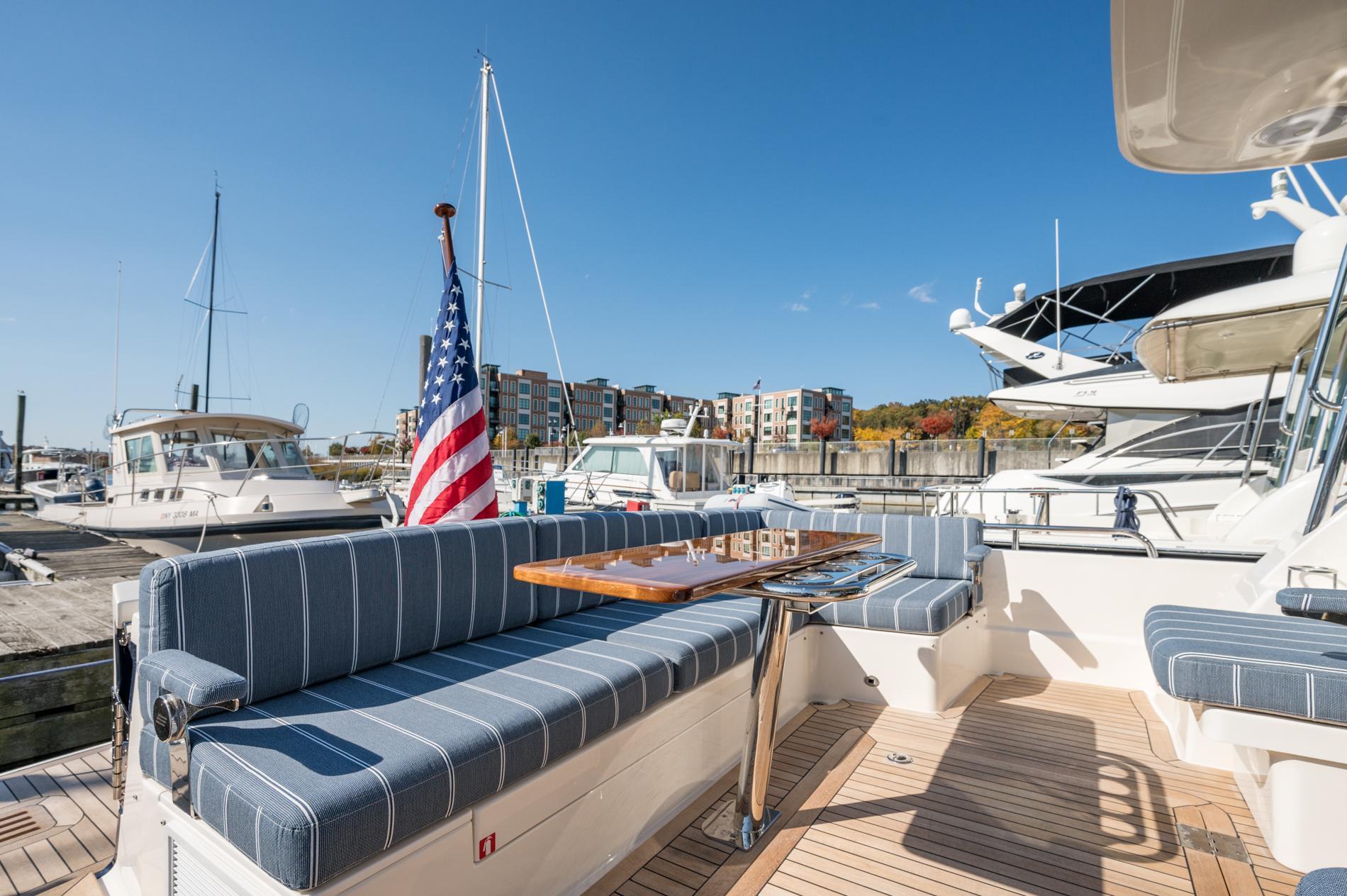 2025 Sabre 43 Salon Express yacht with striped seating and American flag at marina.