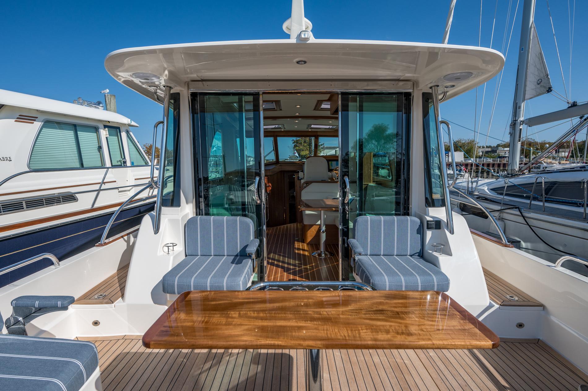2025 Sabre 43 Salon Express yacht with elegant seating and wooden table on deck.