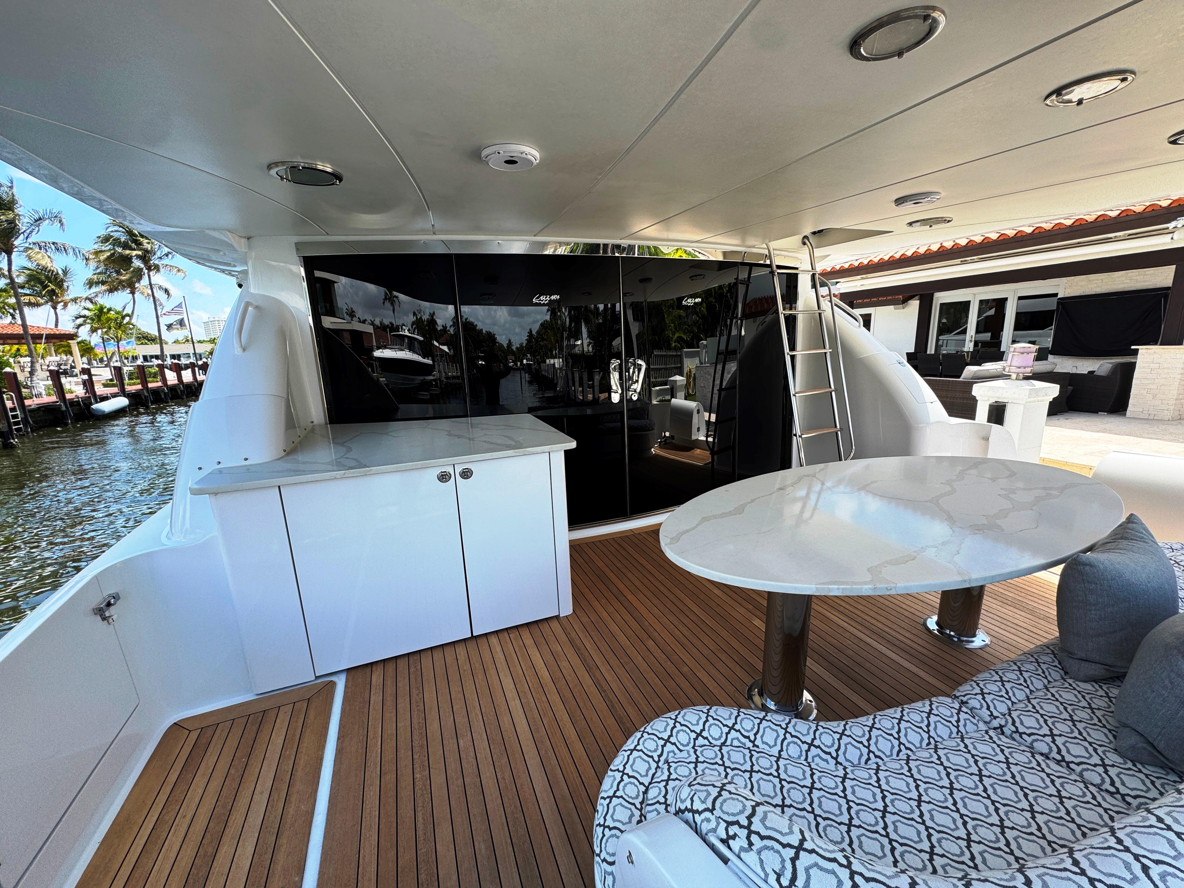 Lazzara-80 Skylounge 2002-Fomo2 FL-US-Luxurious 2002 Lazzara 80 Skylounge yacht deck with elegant seating and table.-9749638 | Thumbnail