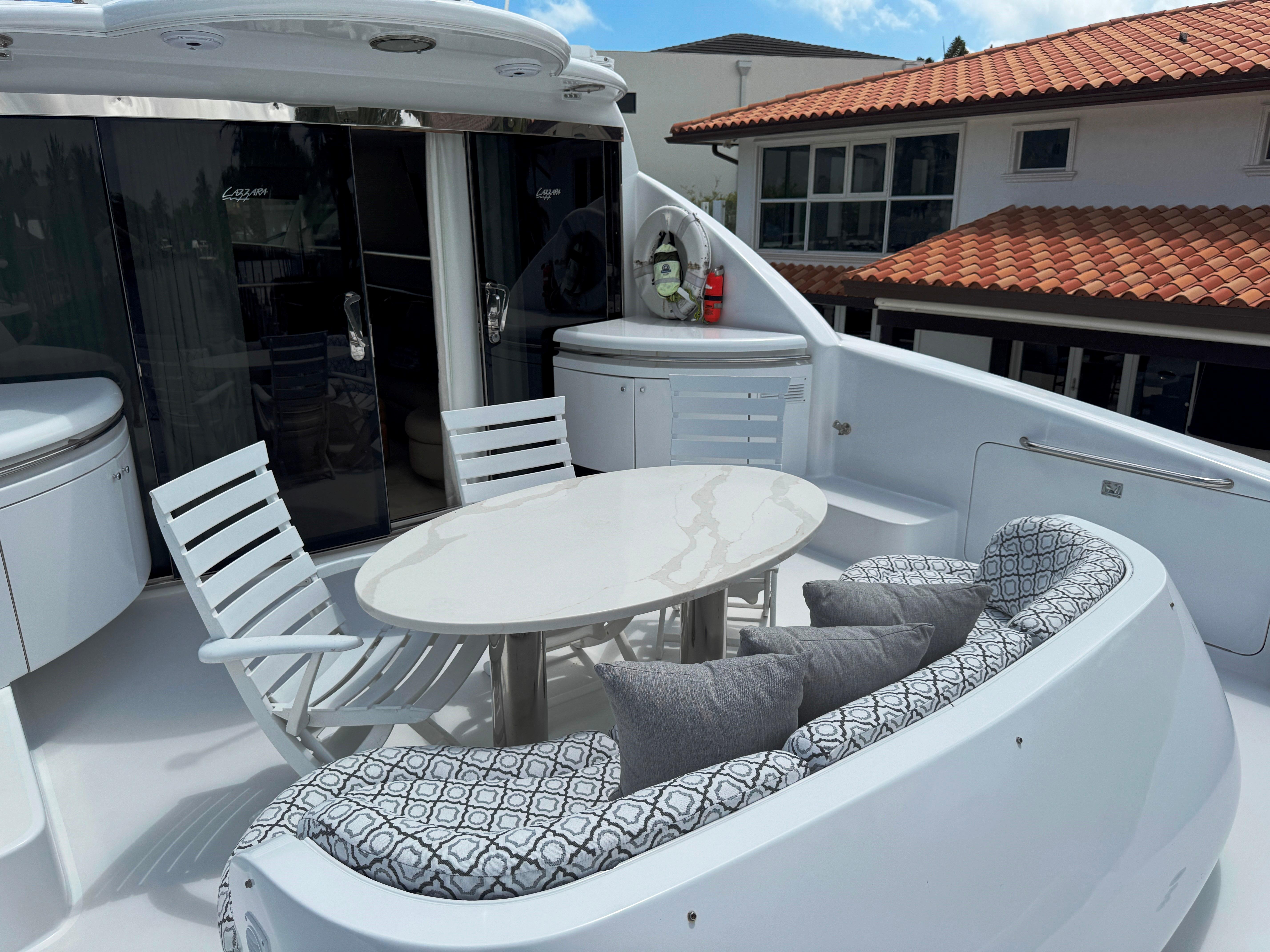 Lazzara-80 Skylounge 2002-Fomo2 FL-US-Luxurious 2002 Lazzara 80 Skylounge yacht deck with elegant seating and table setup.-9749638 | Thumbnail