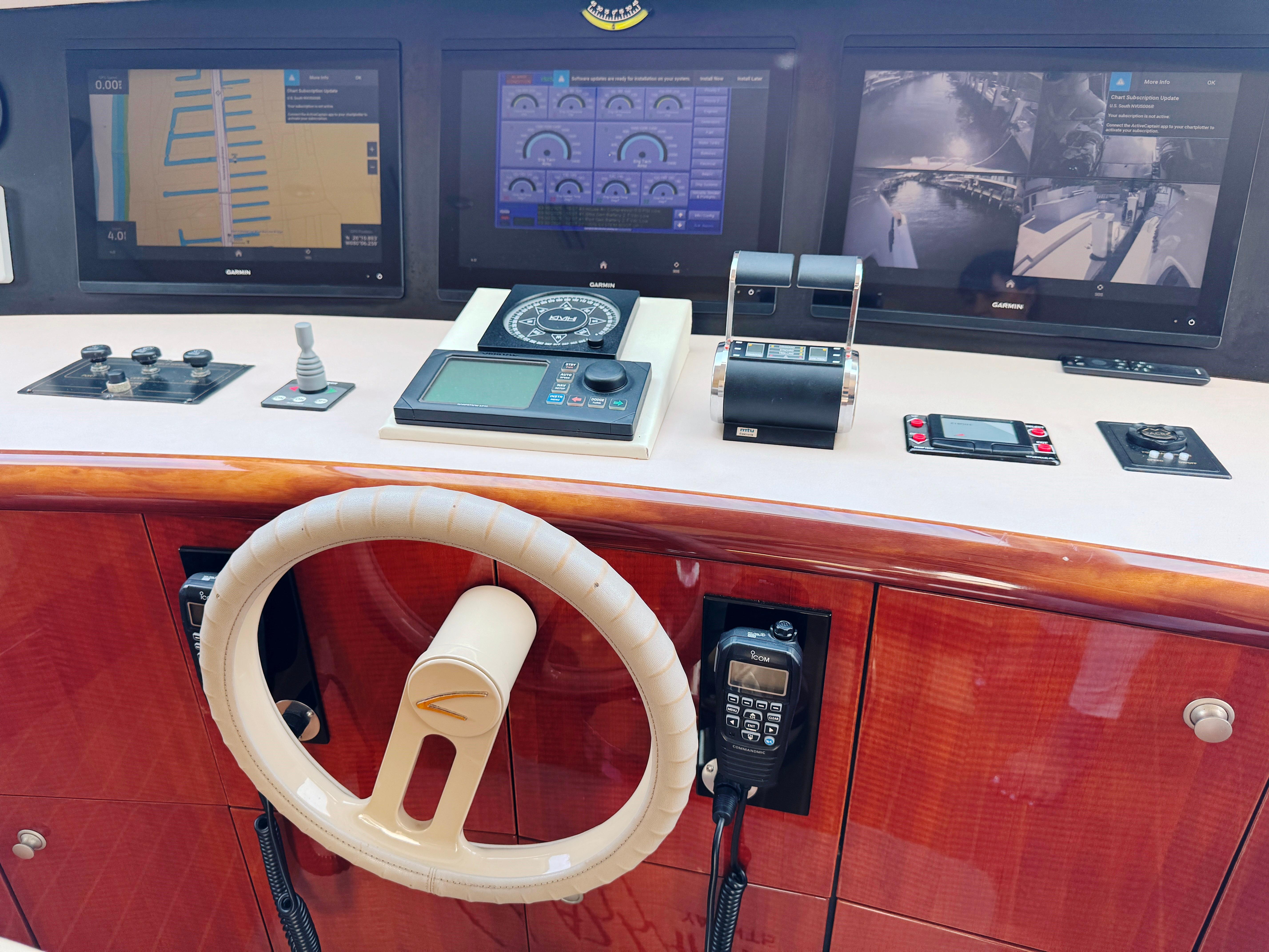 Lazzara-80 Skylounge 2002-Fomo2 FL-US-Control panel of a 2002 Lazzara 80 Skylounge yacht with navigation screens and steering wheel.-9749638 | Thumbnail