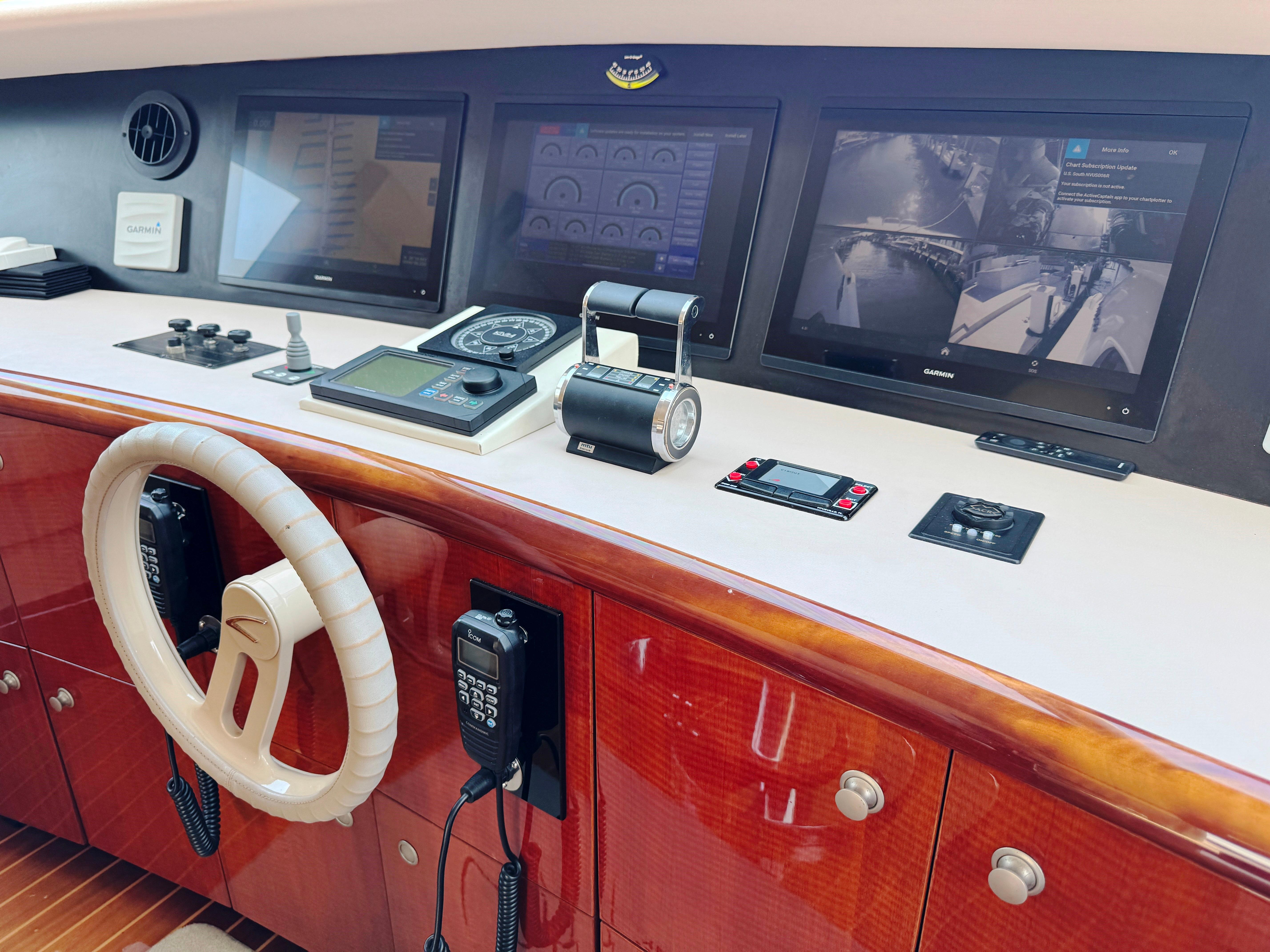 Lazzara-80 Skylounge 2002-Fomo2 FL-US-Control panel of a 2002 Lazzara 80 Skylounge yacht with navigation screens and steering wheel.-9749638 | Thumbnail