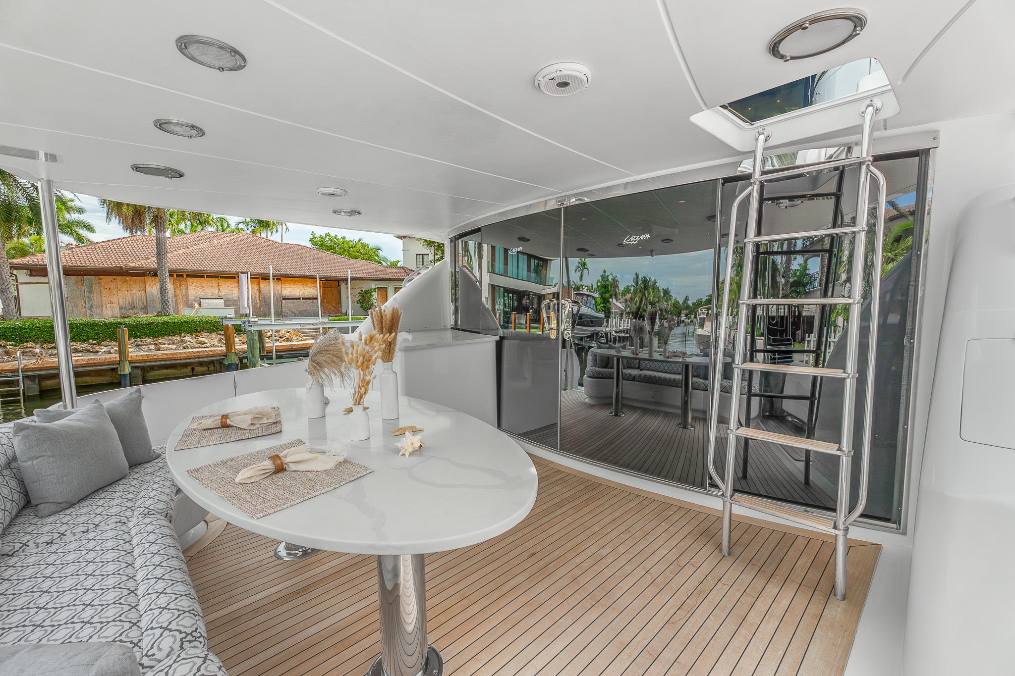 Lazzara-80 Skylounge 2002-Fomo2 FL-US-Luxurious 2002 Lazzara 80 Skylounge yacht deck with elegant seating and dining area.-9749638 | Thumbnail