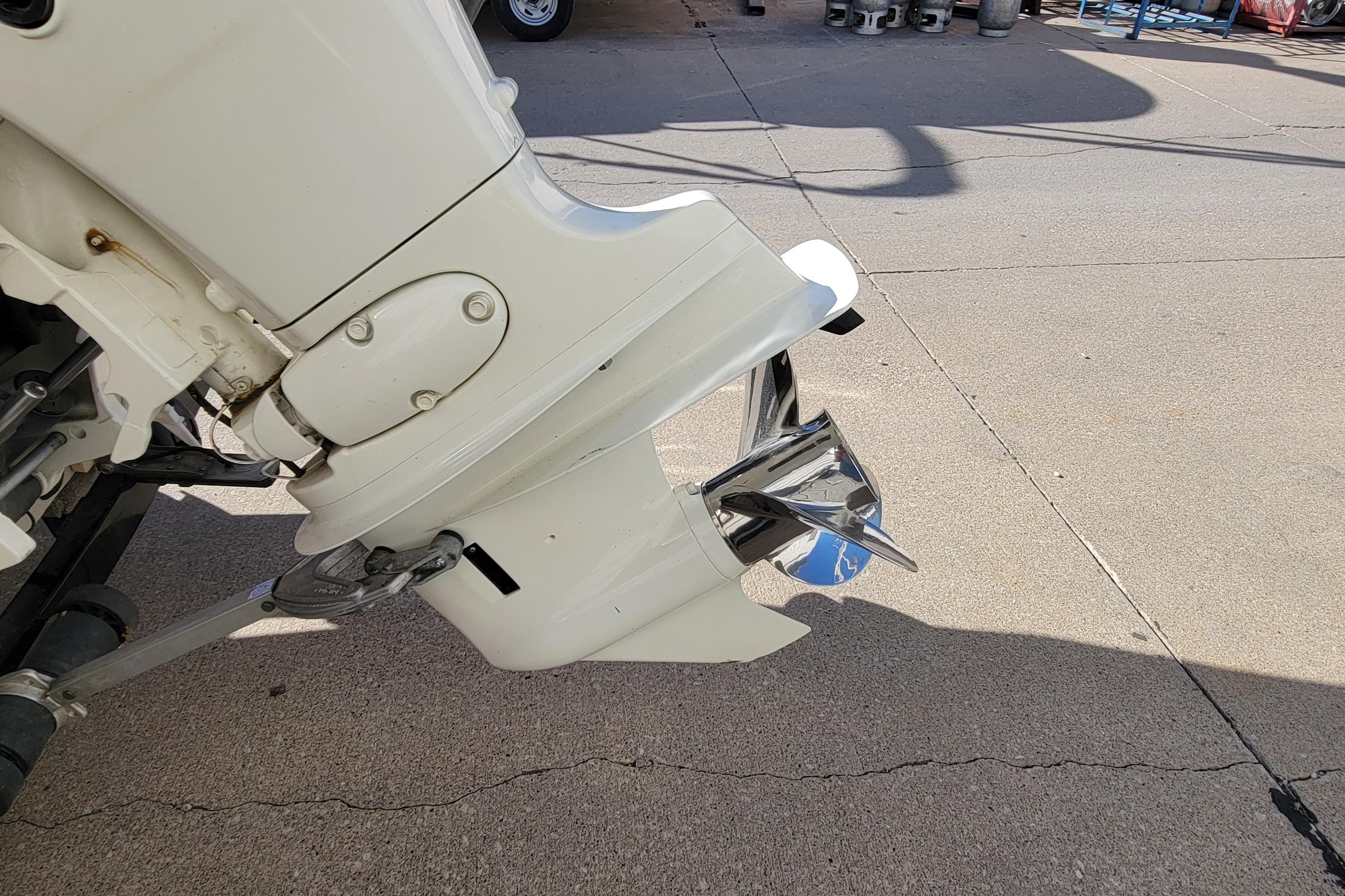 2007 Triton DV 176 Mag boat motor with shiny propeller on concrete surface.
