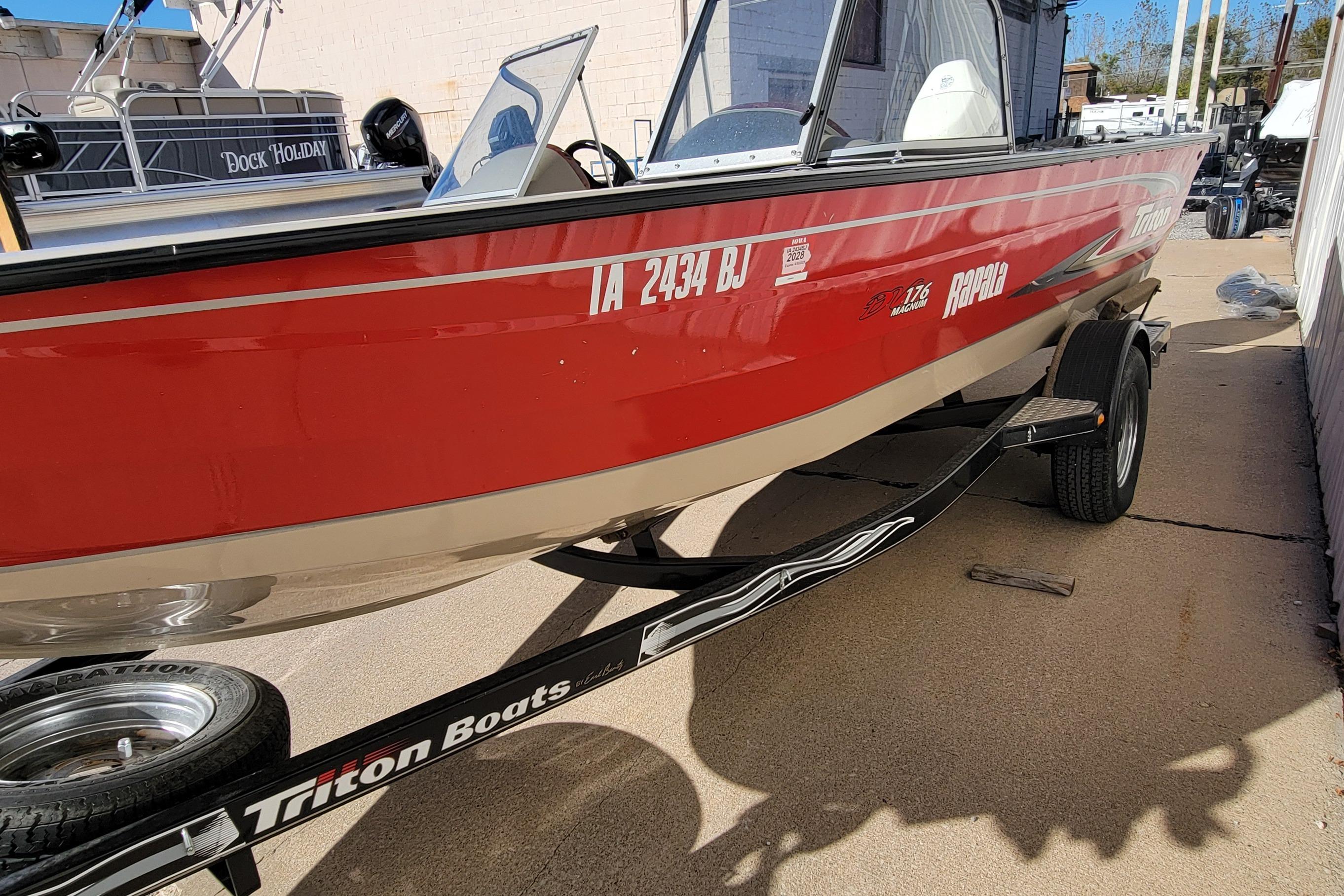 2007 Triton DV 176 Mag red boat on trailer, parked outdoors.