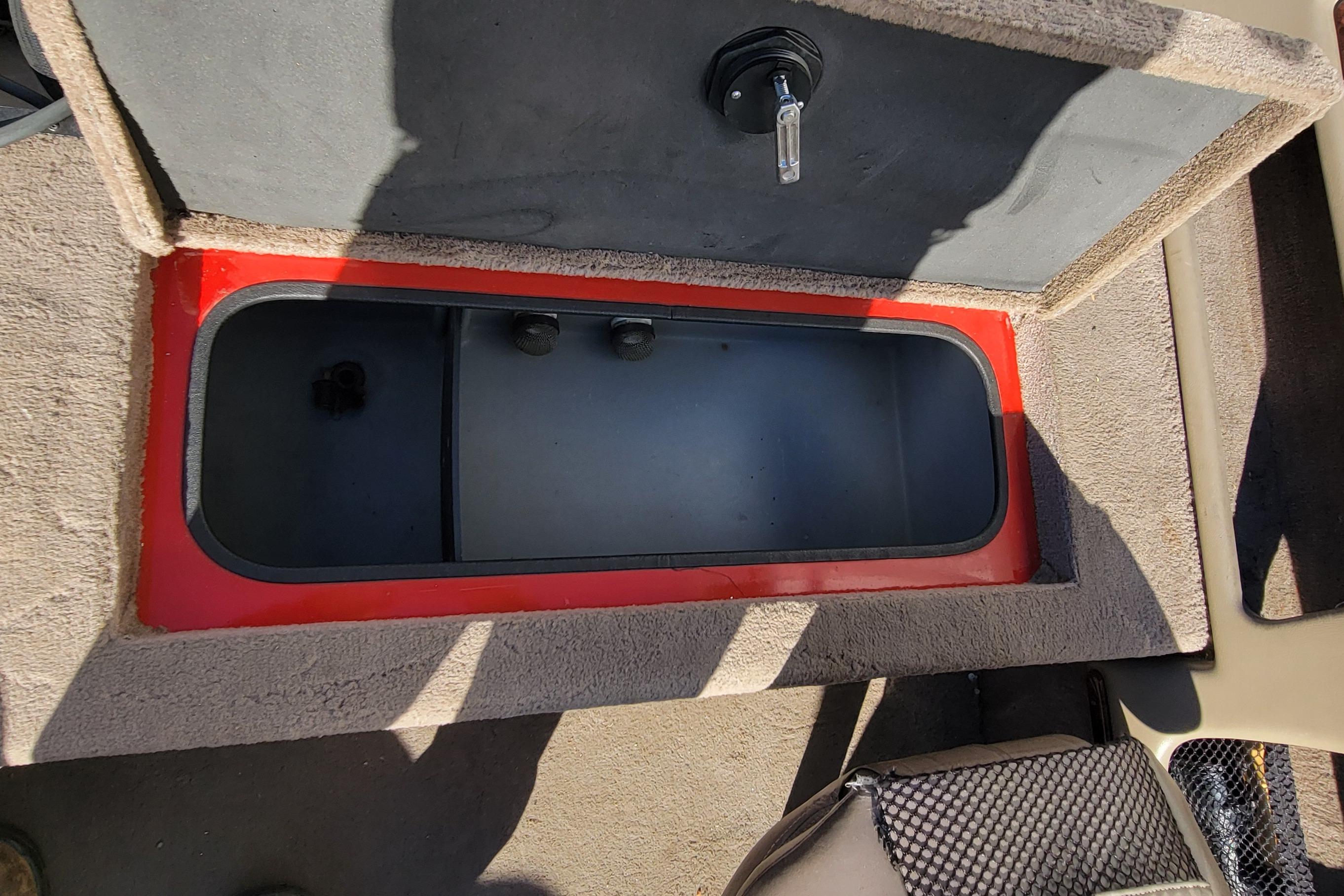 2007 Triton DV 176 Mag boat storage compartment with red trim and carpeted interior.