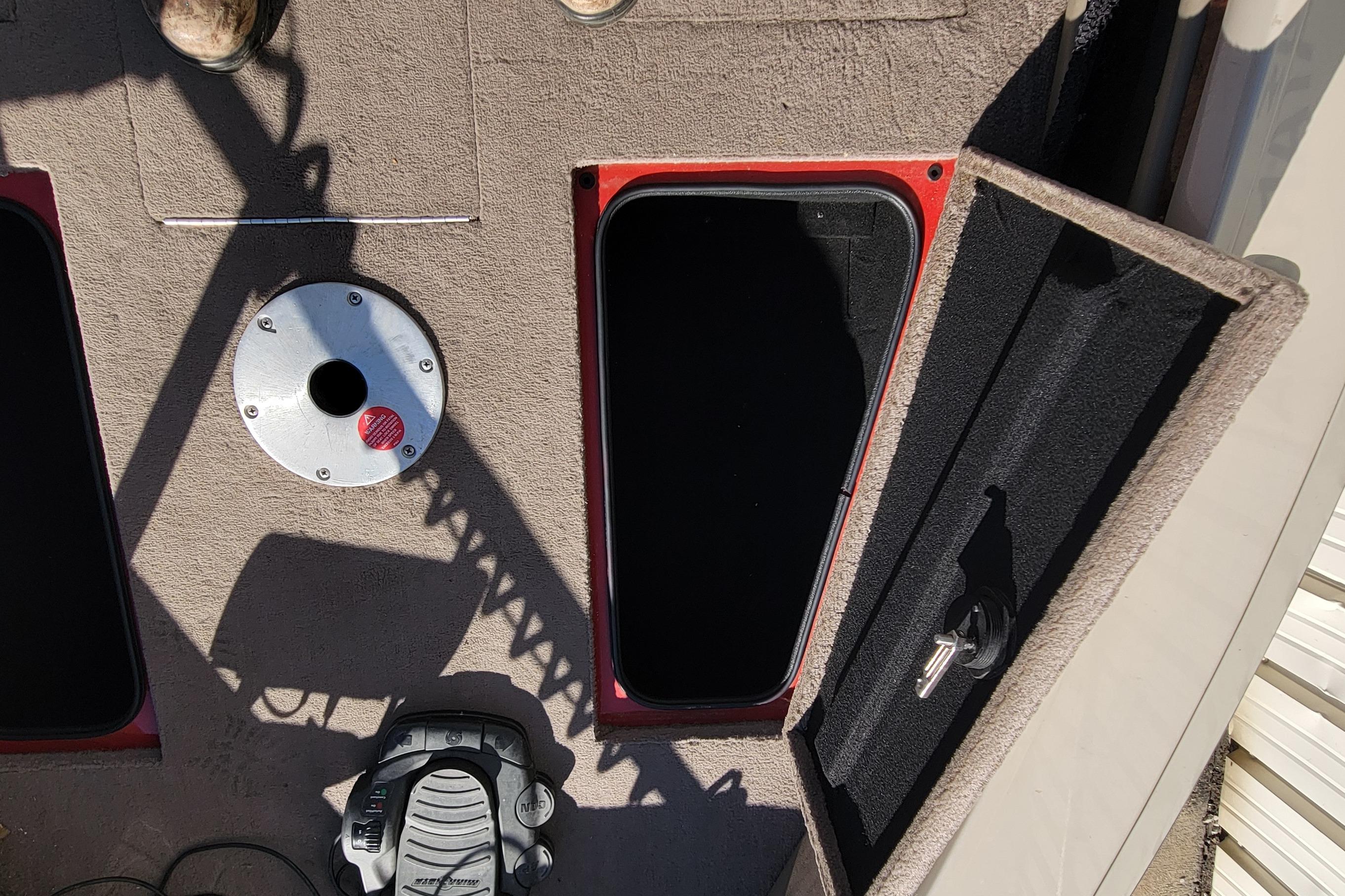 2007 Triton DV 176 Mag boat interior with open storage compartment and pedal.