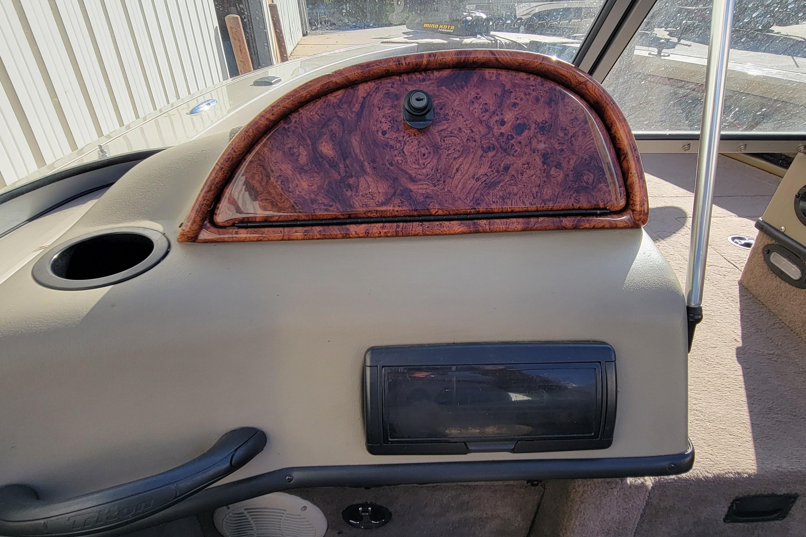2007 Triton DV 176 Mag boat dashboard with wood paneling and storage compartments.